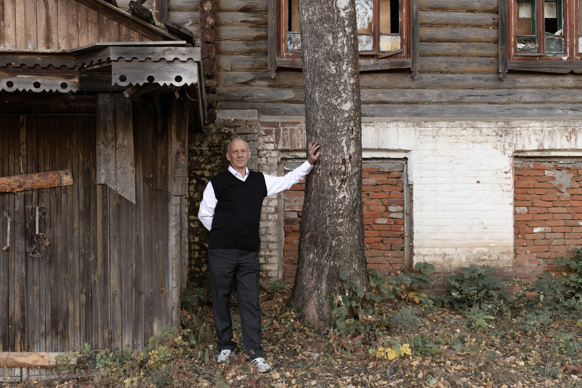 64-летний Александр Савкин — потомок первого коммунара Ивана Осиповича Лапского, приехавшего в Иру из Америки. Он позирует для снимка на фоне дома, где провёл детство, рядом с берёзой, которую посадил сам. "— Тут, в беседке, играл духовой оркестр, — вспоминает Александр Кириллович. — Очень знаменитый, ребята и на трубе, и на саксофоне, и на альте, и на барабанах — вот на всём играли. И когда сюда приходил духовой оркестр, его слышно было на всю деревню. На всю деревню, даже до Овсяновки! А это 7-8 километров."