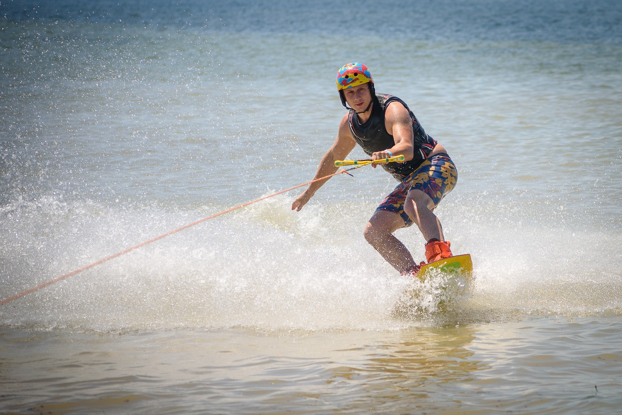 Спортсмен мчится на скимборде по волнам