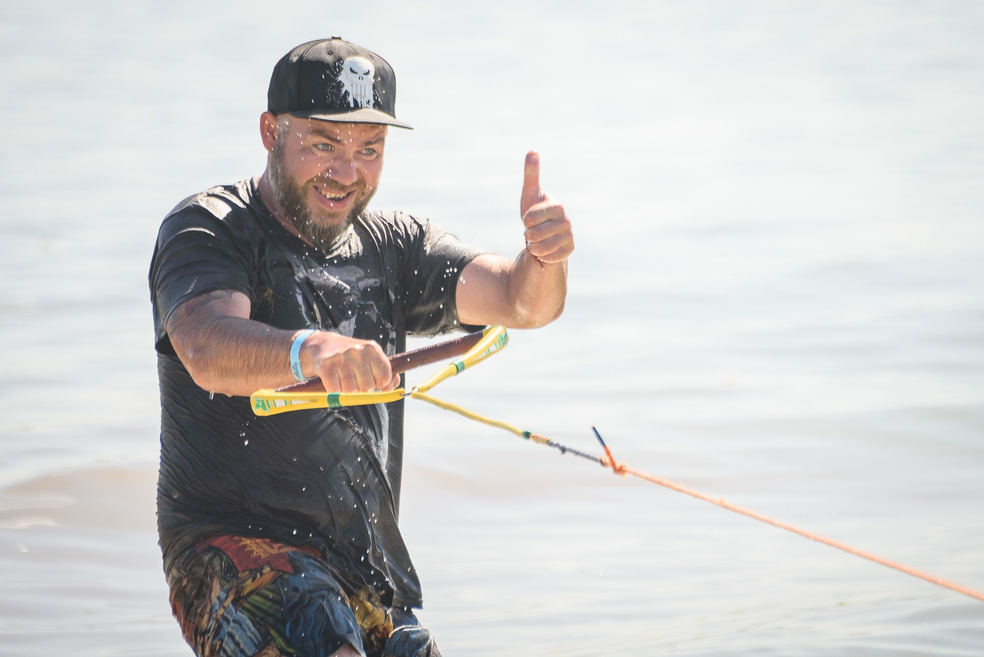 Спортсмен в бейсболке на скимборде показывает лайк