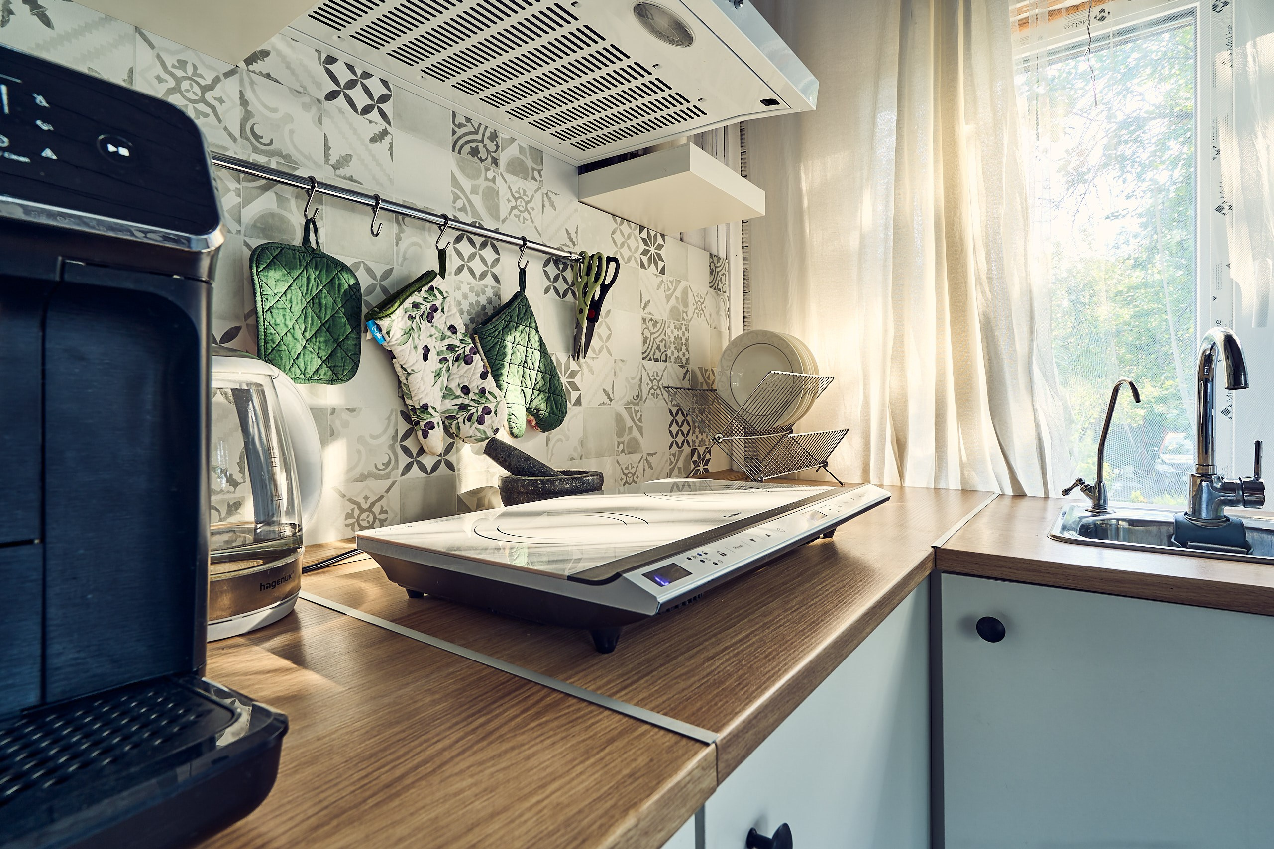 Интерьерная фотосъемка с тонущими в золотом закатном свете краном, посудой и индукционной плитой