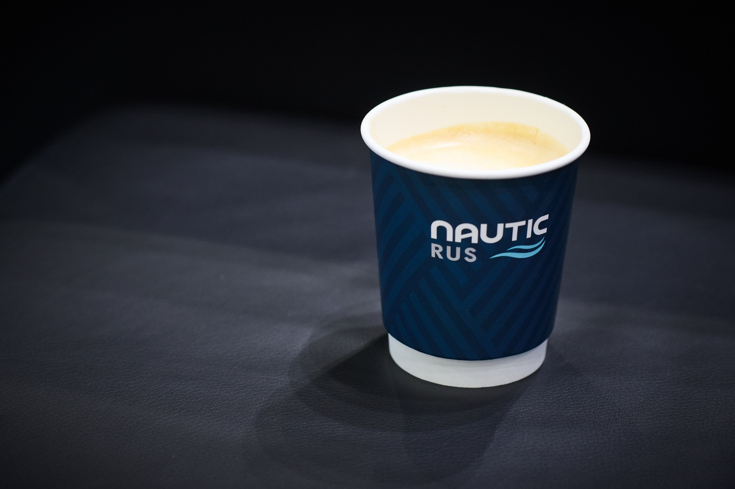 Чашка готового кофе на стенде Nautic Rus. Seafood Expo Russia 2025, репортажная съёмка, Экспофорум, Санкт‑Петербург.