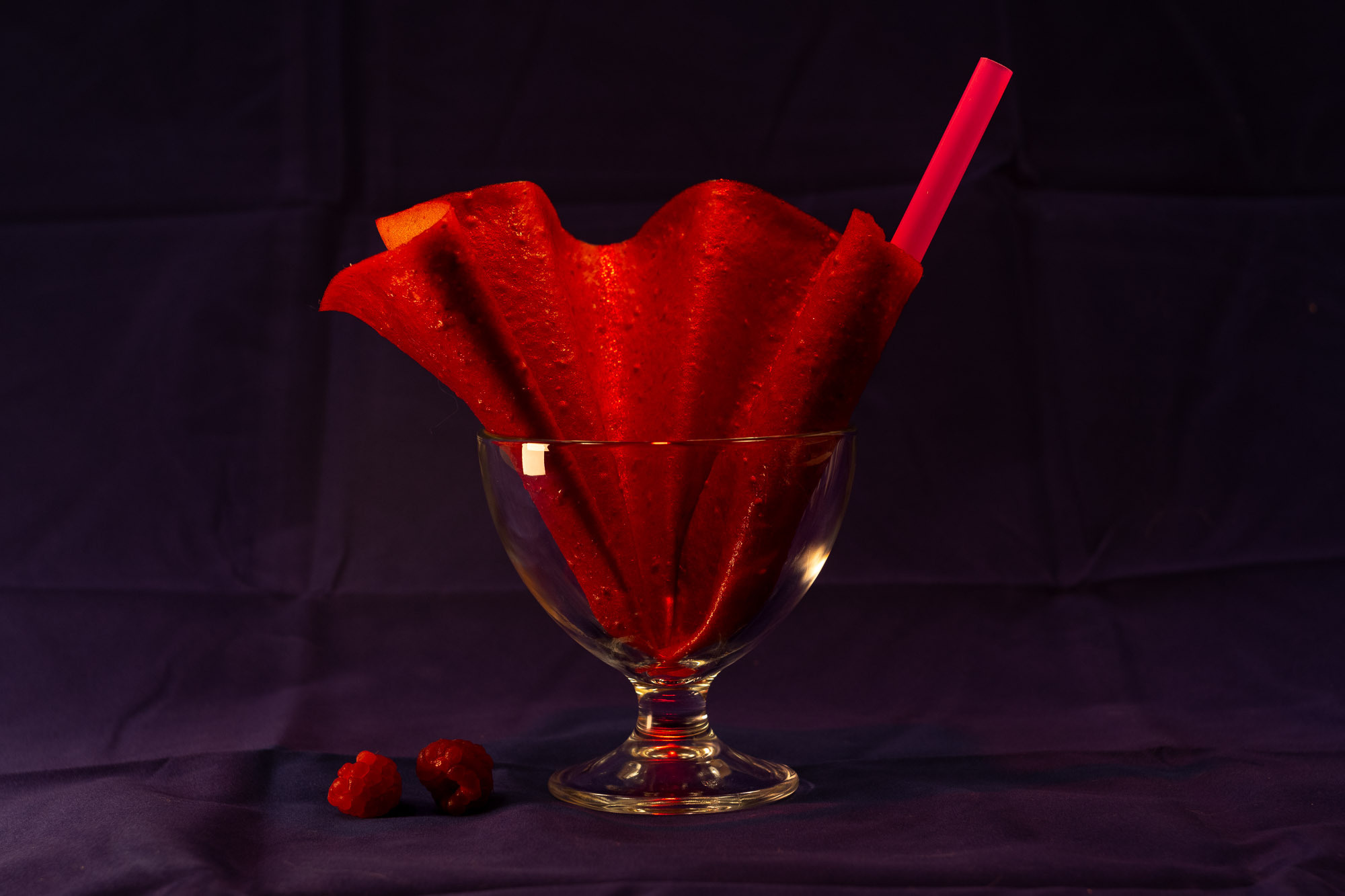 Фруктовая пастила. Вид сверху. Загадочная композиция, розовая соломинка, пастила как веер, свежие ягоды малины вокруг.