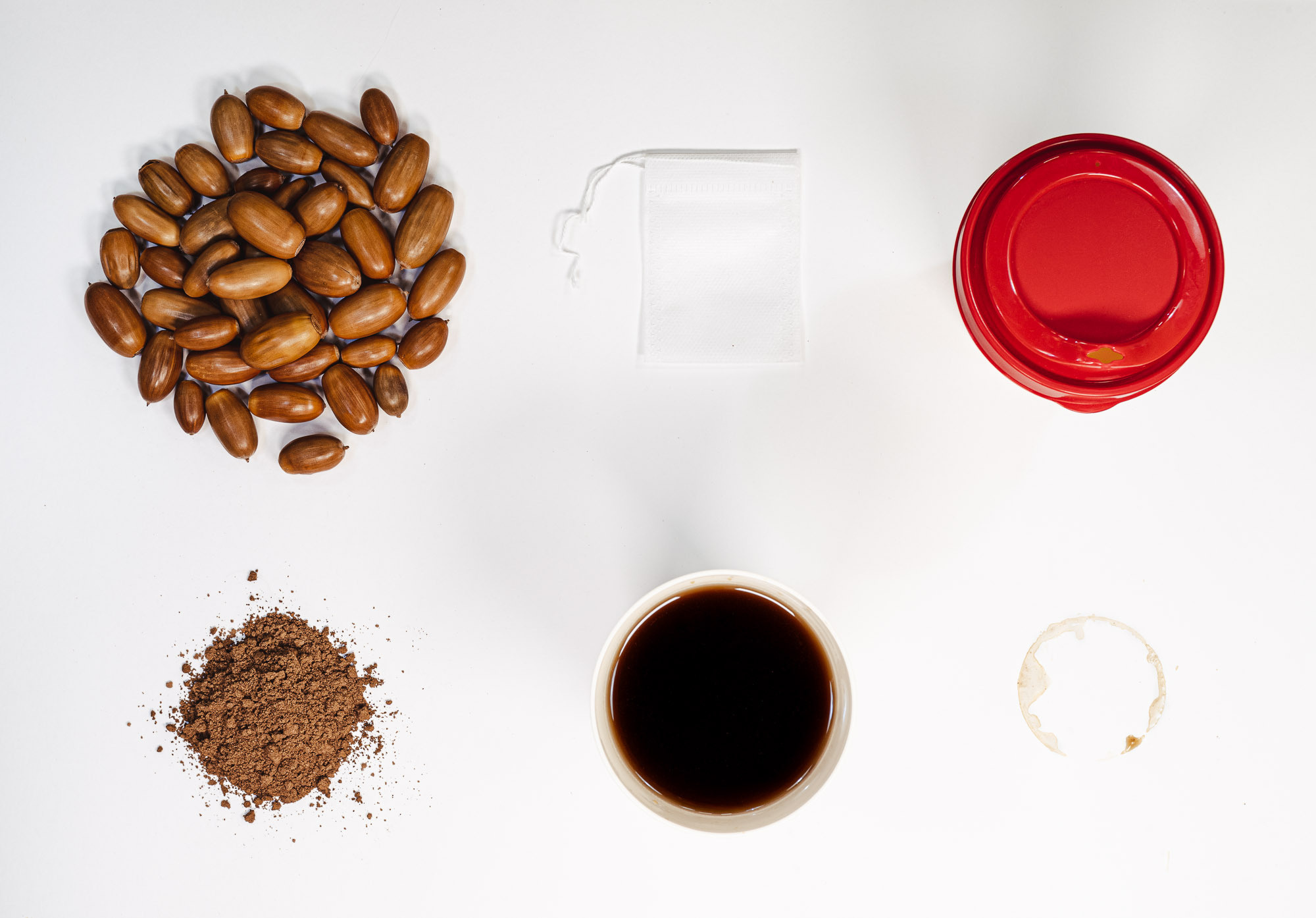 Вид сверху. Художественная фотография. Шесть предметов, красный стакан, след от кофе, кофейные зерна, чашка с кофе, желудевый кофе