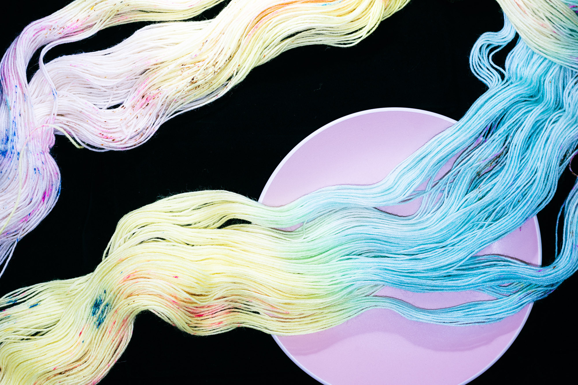 Пряжа как волна в море на розовом блюдце и черном фоне