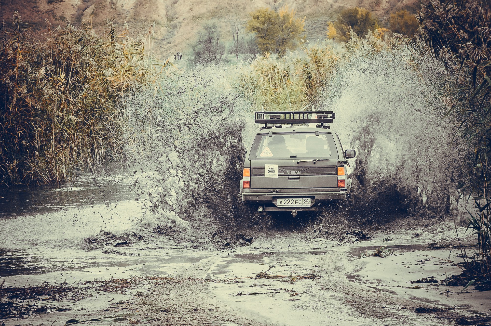 Автомобиль заезжает на скорости в воду, подняв фонтан брызг