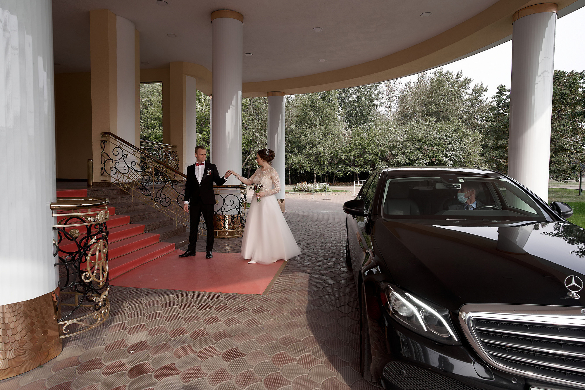 Парадный вход в Дом торжеств Сафиса. Жених под руку ведет невесту в Загс . На фоне свадебного автомобиля. Свадебный фотограф в Москве Сергей Гаварос gavaros.ru