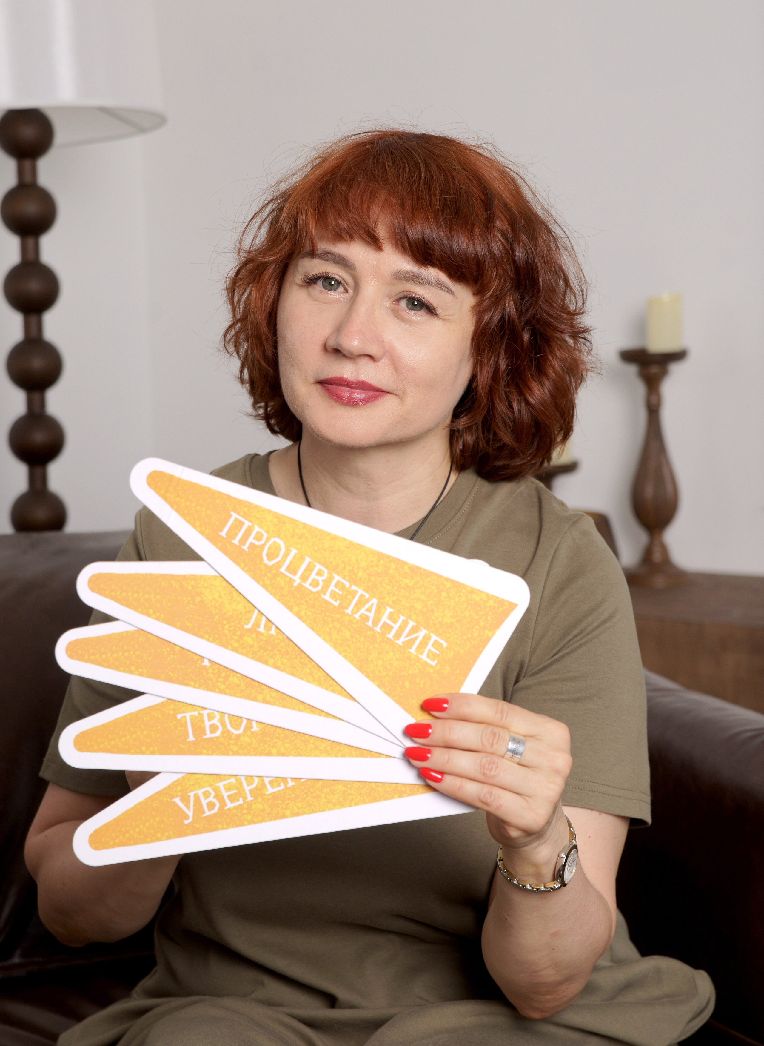 Контент съемка - женщина сидя показывает карточки