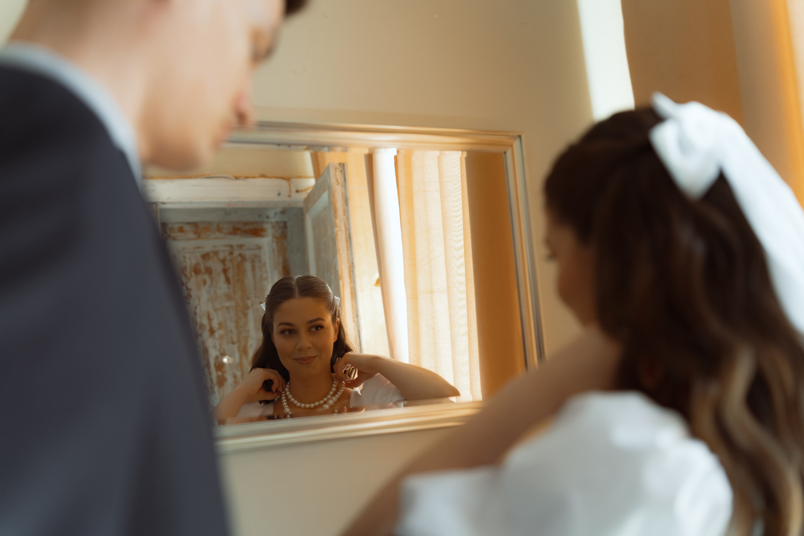 Взгляд жениха на невесту в зеркало, эмоциональный свадебный момент