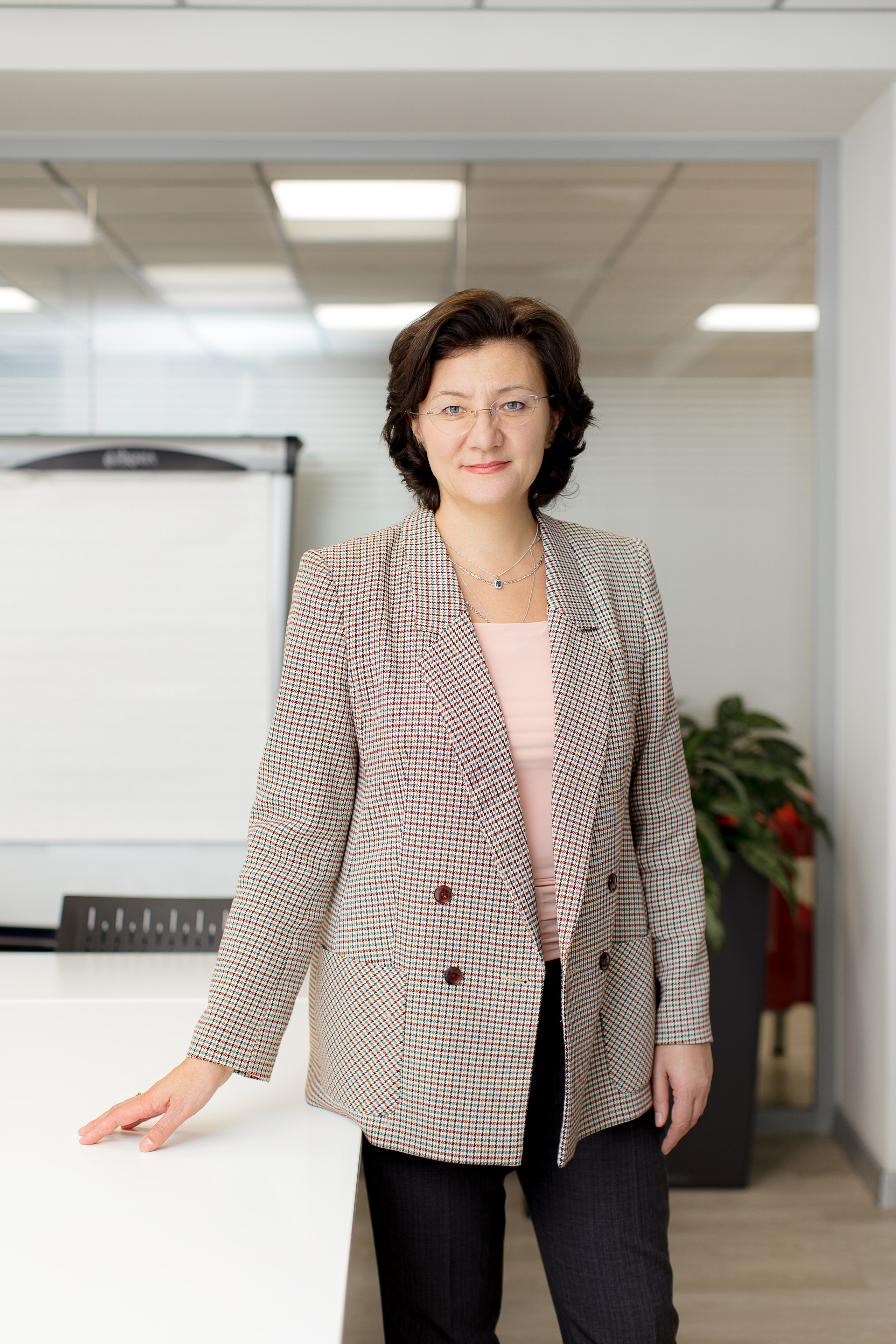 Портрет женщины руководителя в пиджаке в интерьере офиса