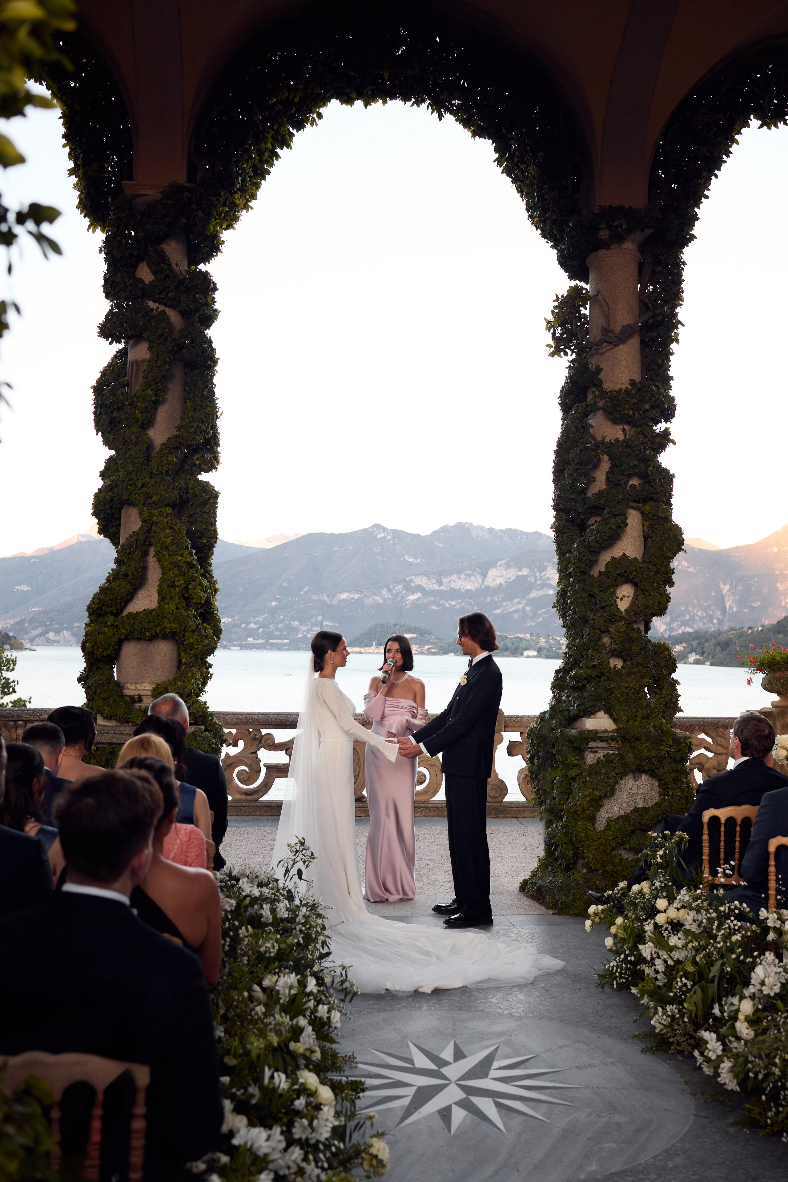Groom and wedding guest celebrating on a terrace by the lake