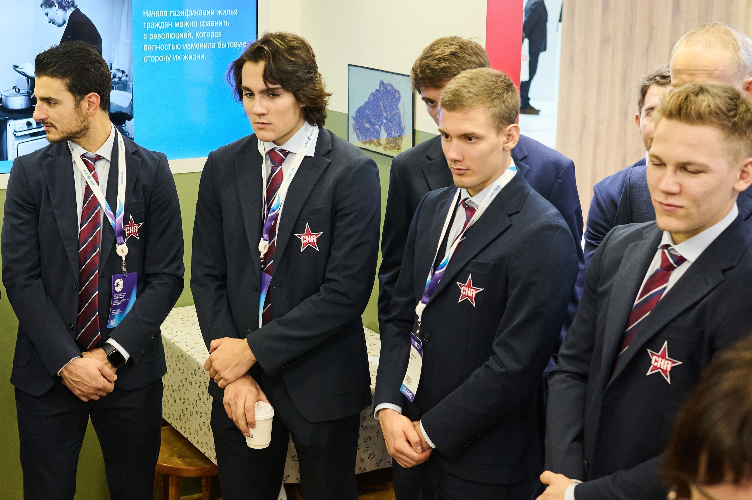 Игроки команды СКА изучают стенд и слушают объяснения на Петербургском международном газовом форуме 2025 в Экспофоруме