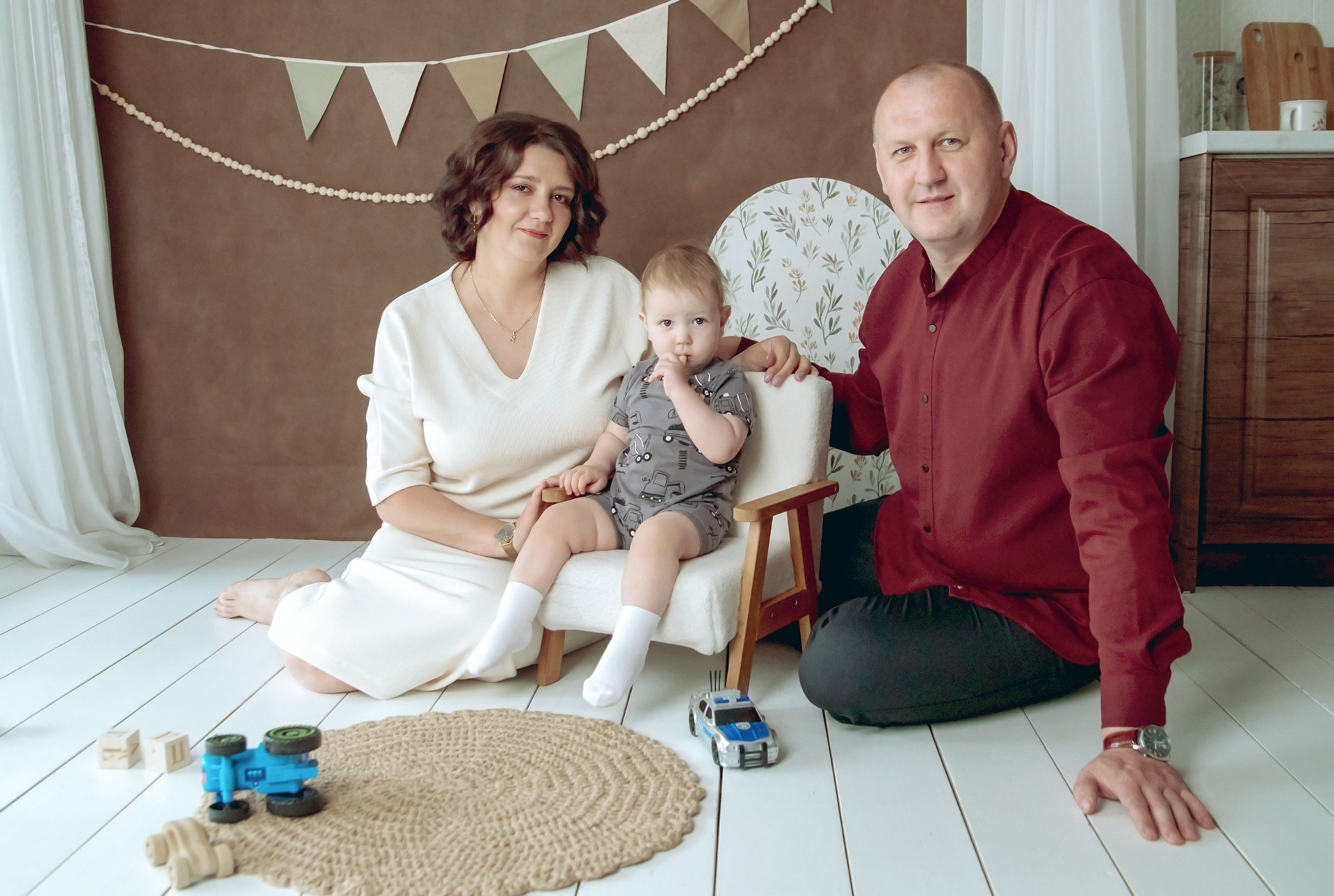 Семейная фотосессия в студии - родители рядом с мальчиком на полу