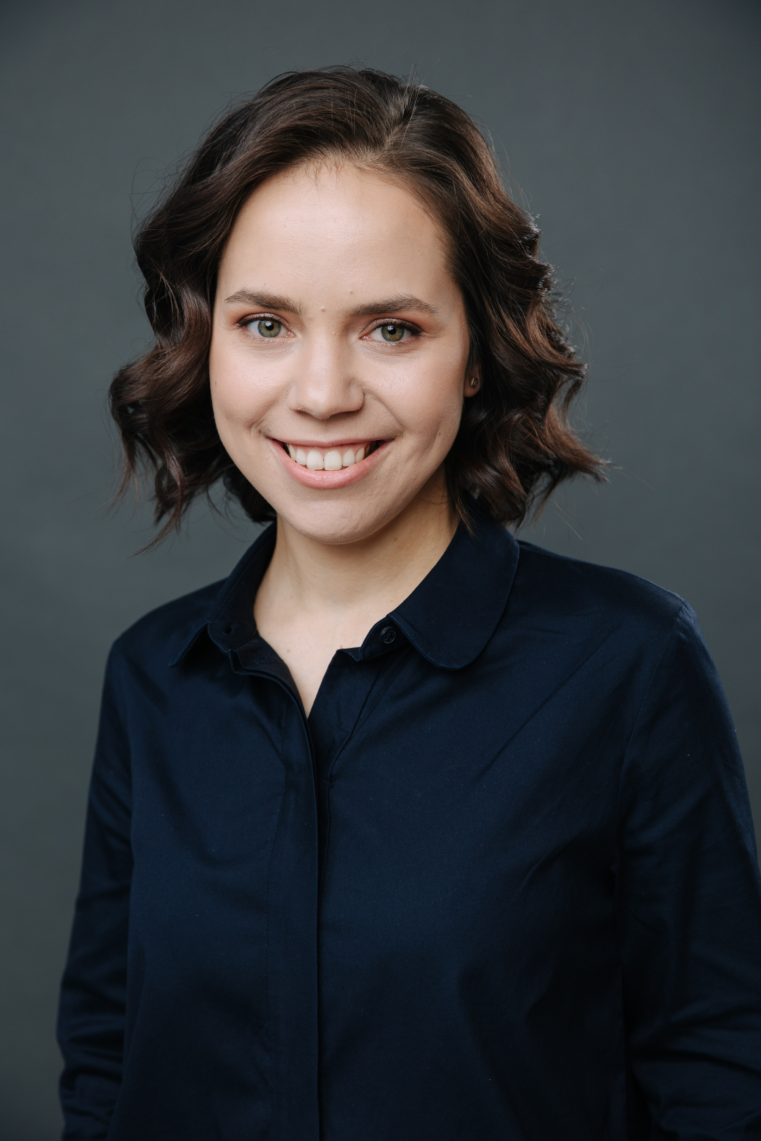 хедшот фотография для сотрудника компании, крупный портрет девушки на темном фоне