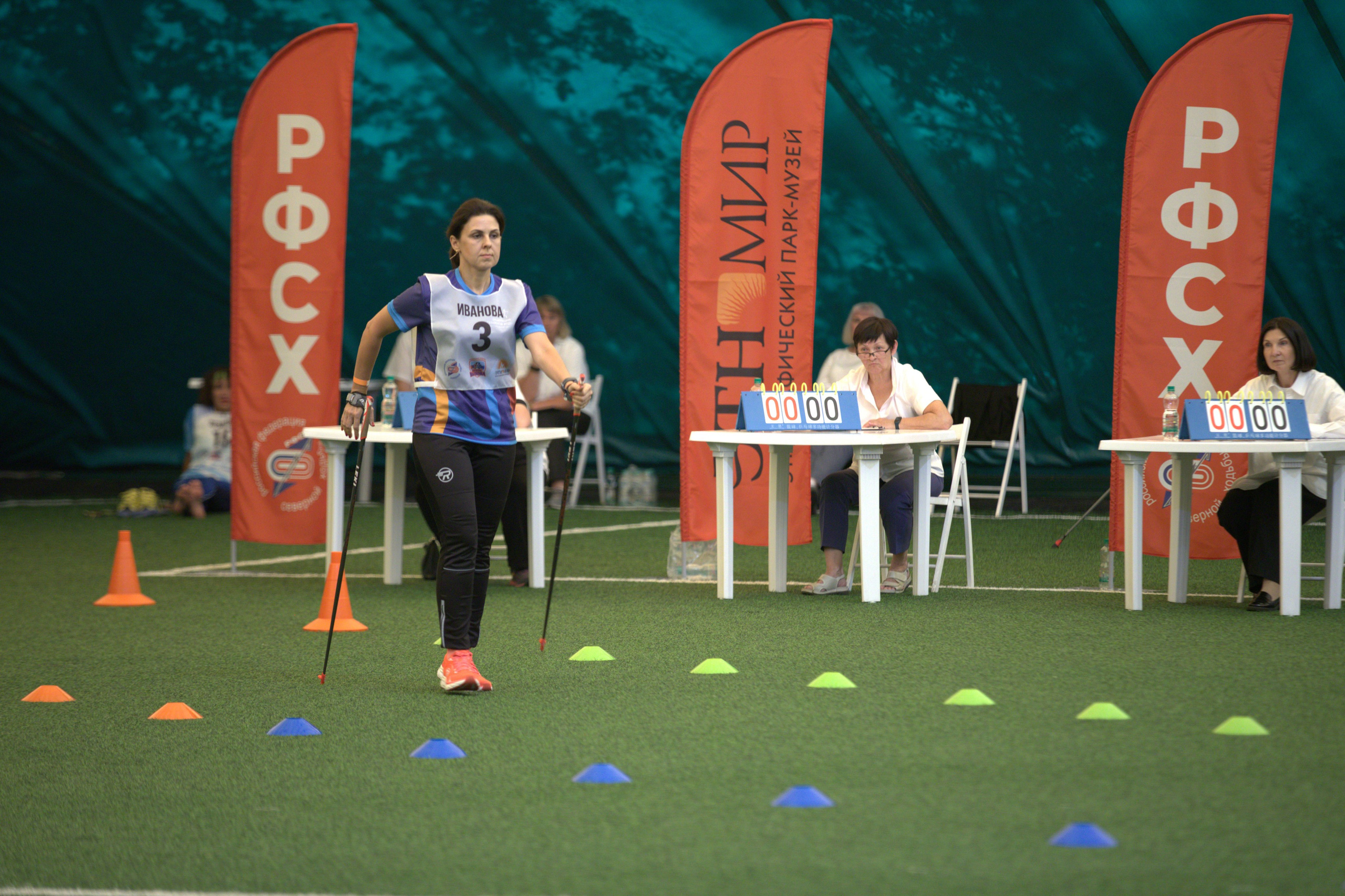 Спортсменка на фоне судей по Северной ходьбе