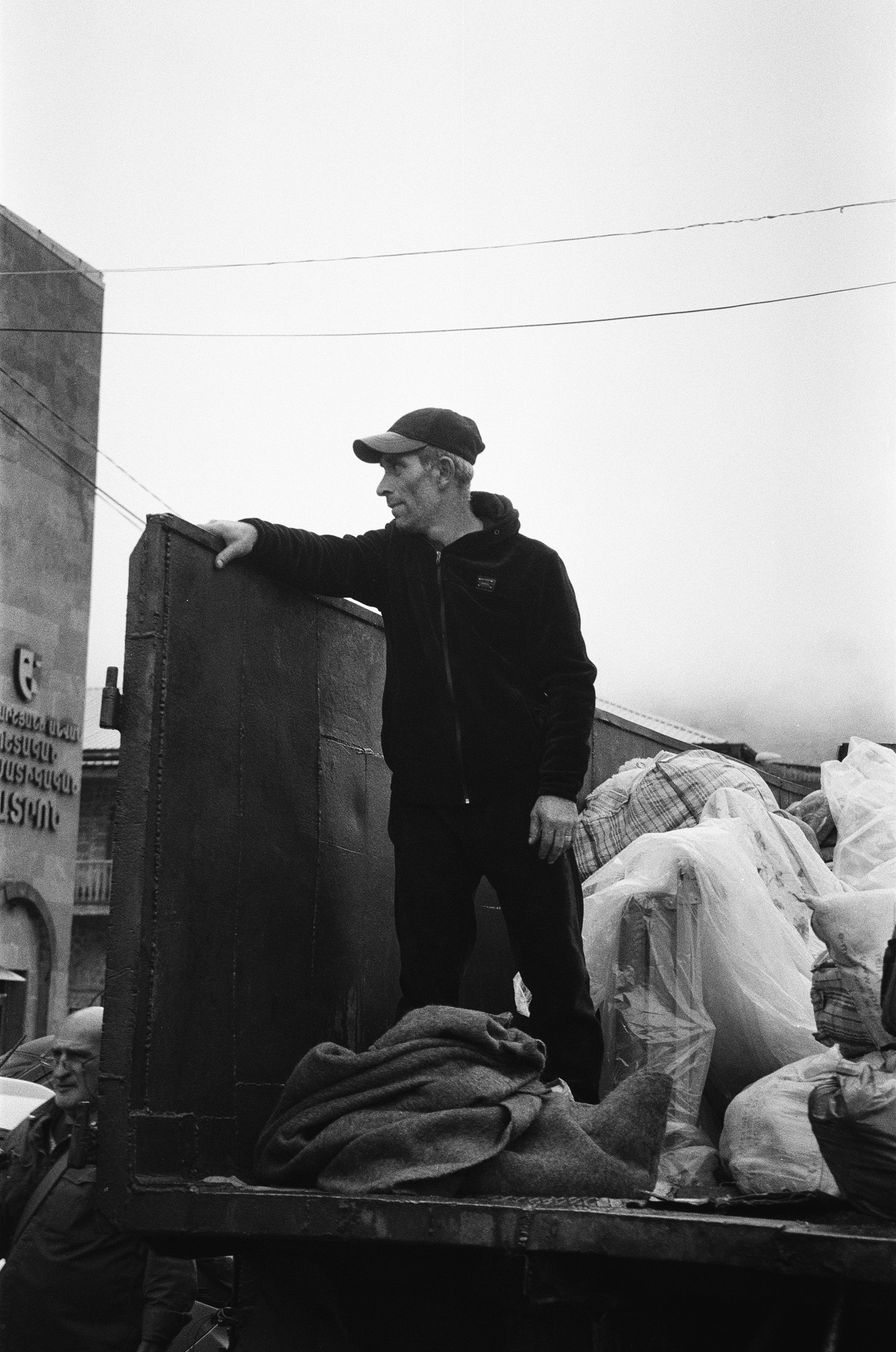 A man is unloading belongings of refugees from a truck