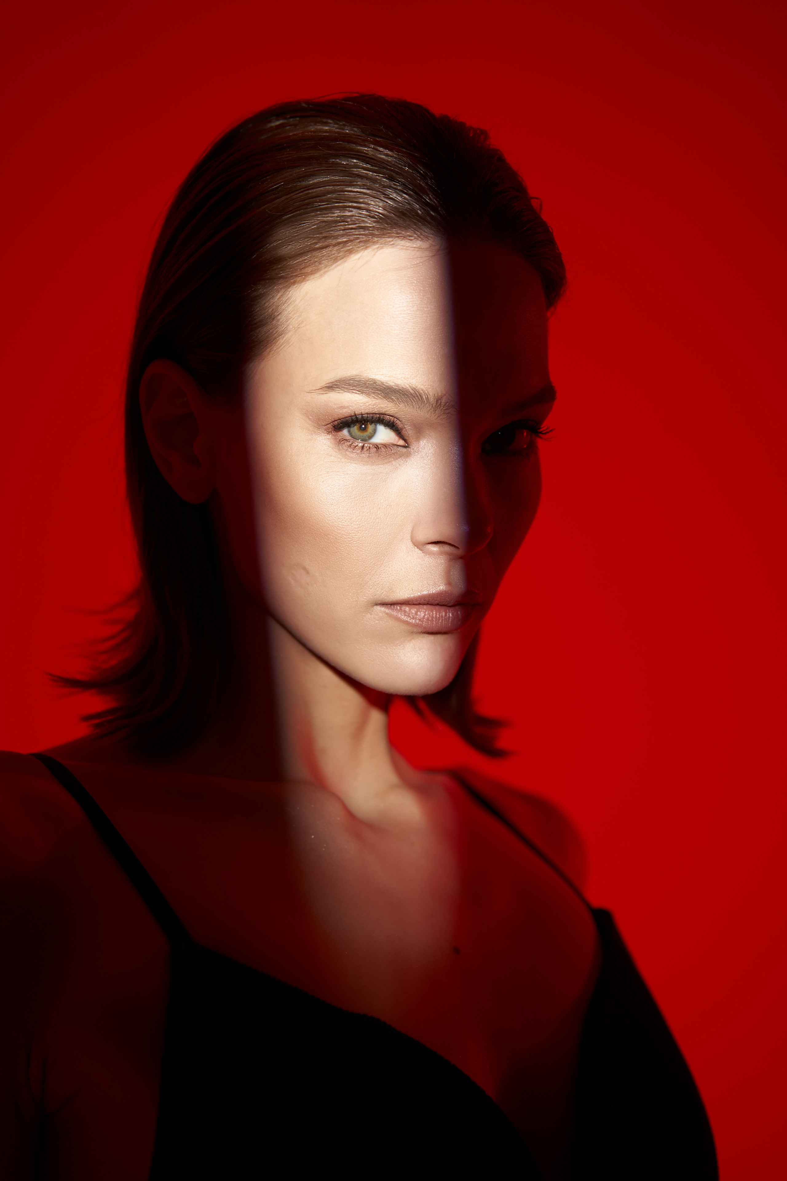 женский портрет с лучом света на красном фоне