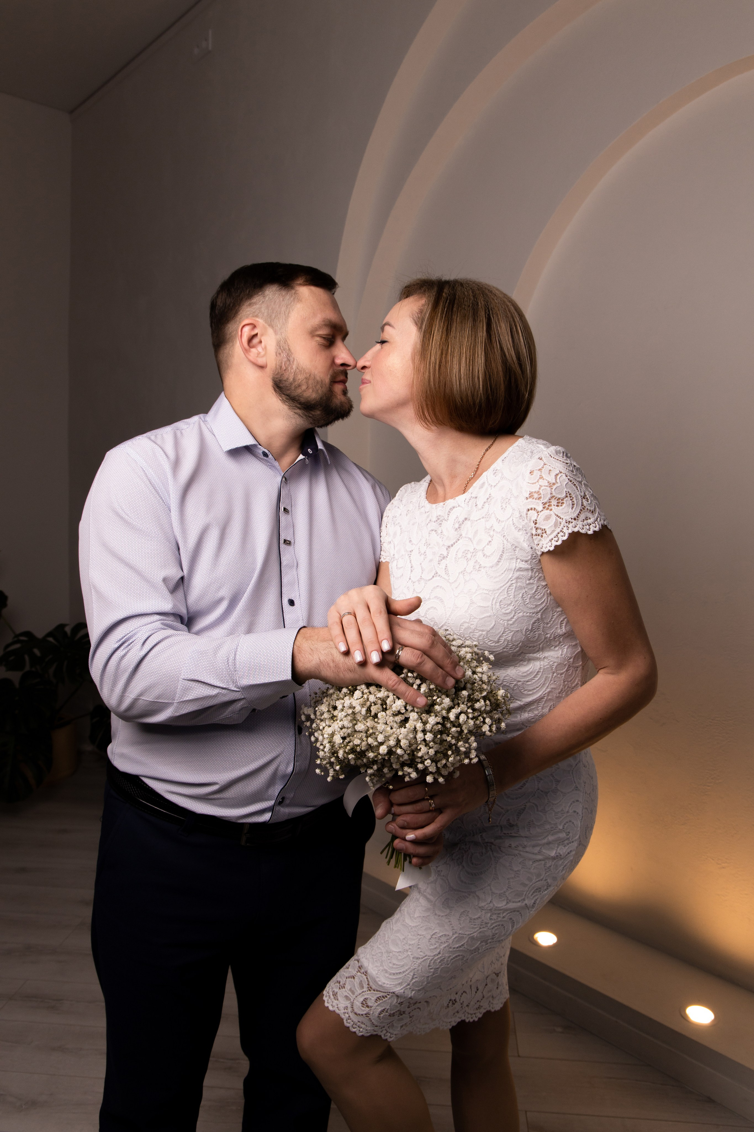 Молодожены целуются и держатся за руки. Свадебная фотосессия Астрахань.