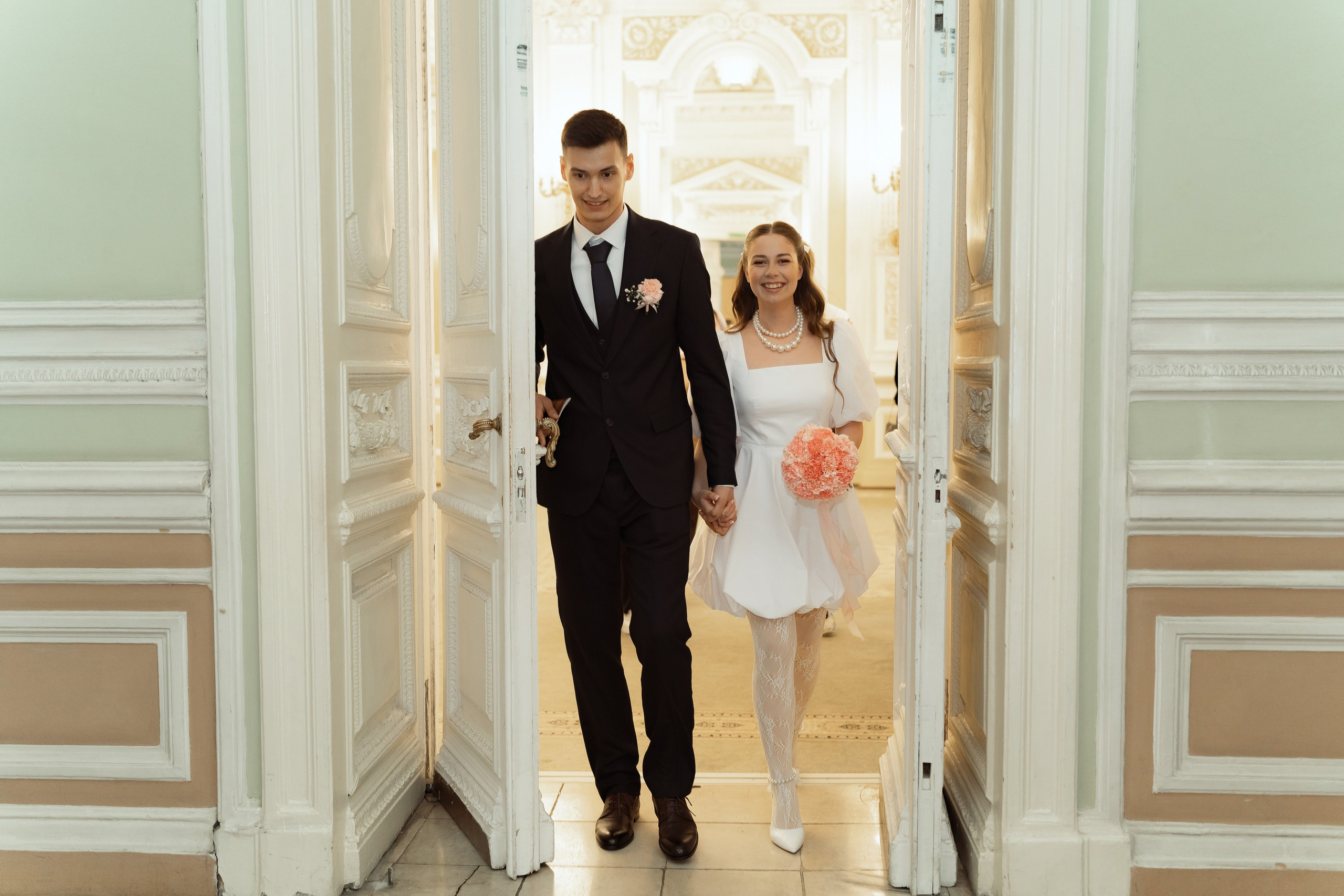 Молодожёны выходят из зала регистрации брака, эмоциональный момент свадьбы