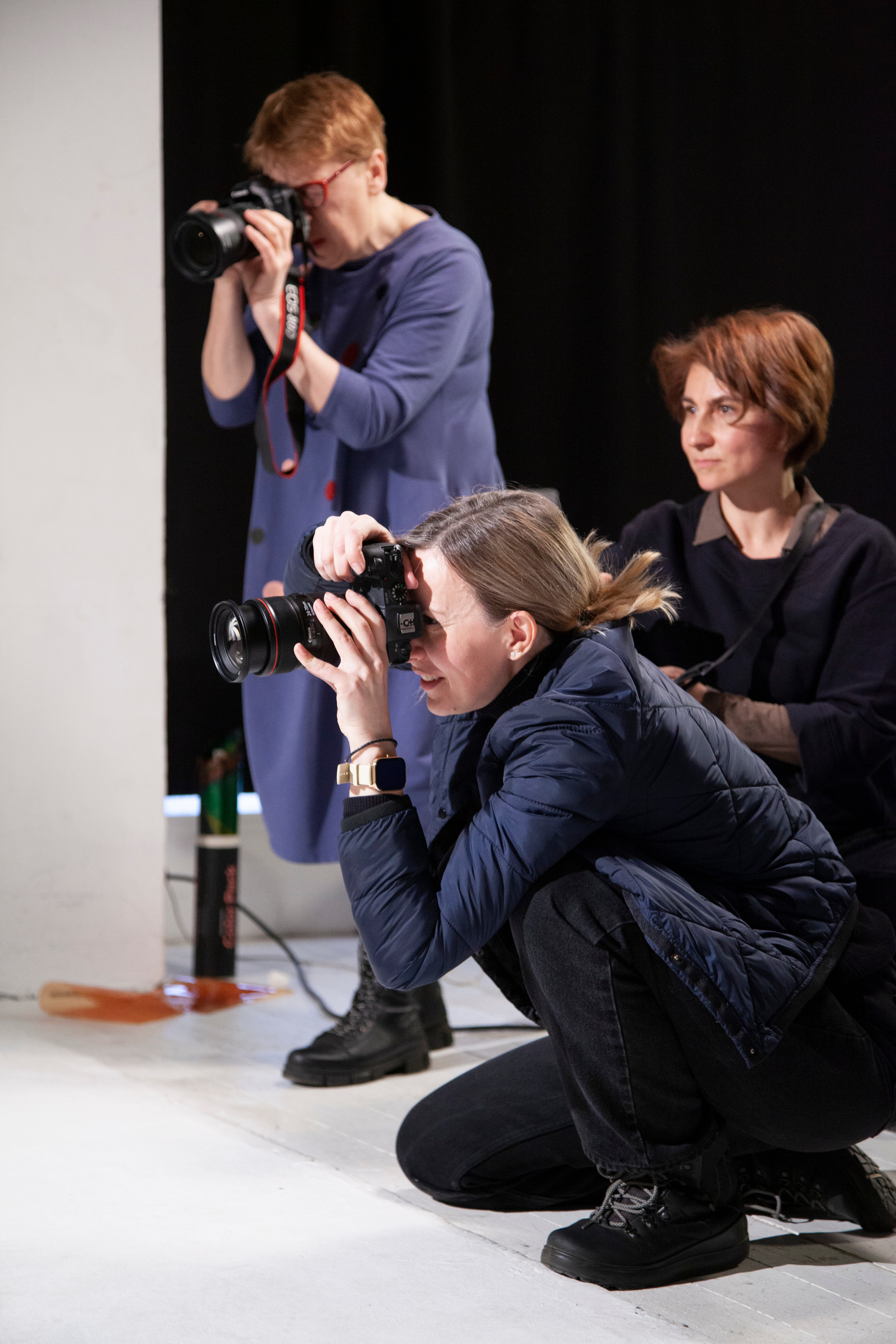 Фотографы через объективы фотокамер прицельно наблюдают за моделью на съемке