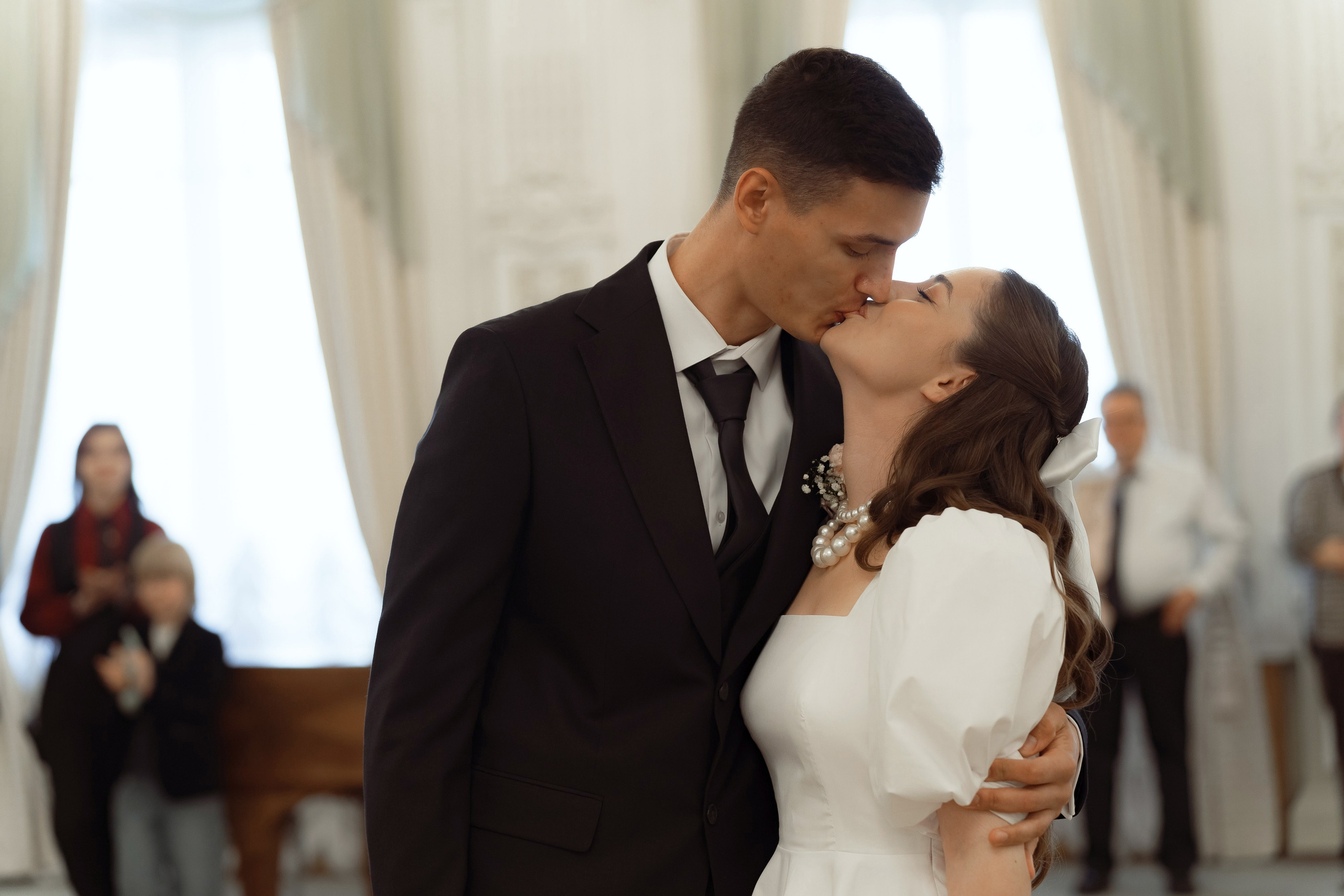 Эмоциональный и нежный момент поцелуя жениха и невесты на церемонии