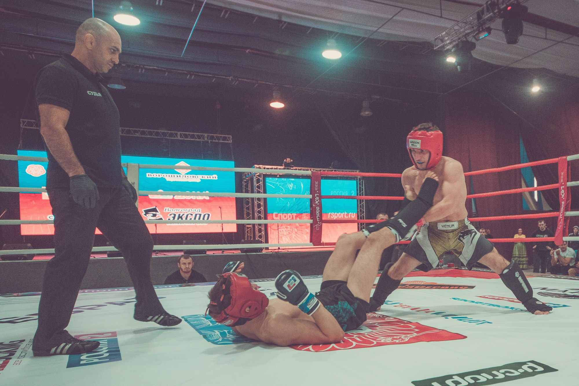 Спортсмен на ринге отбивается от соперника ногами
