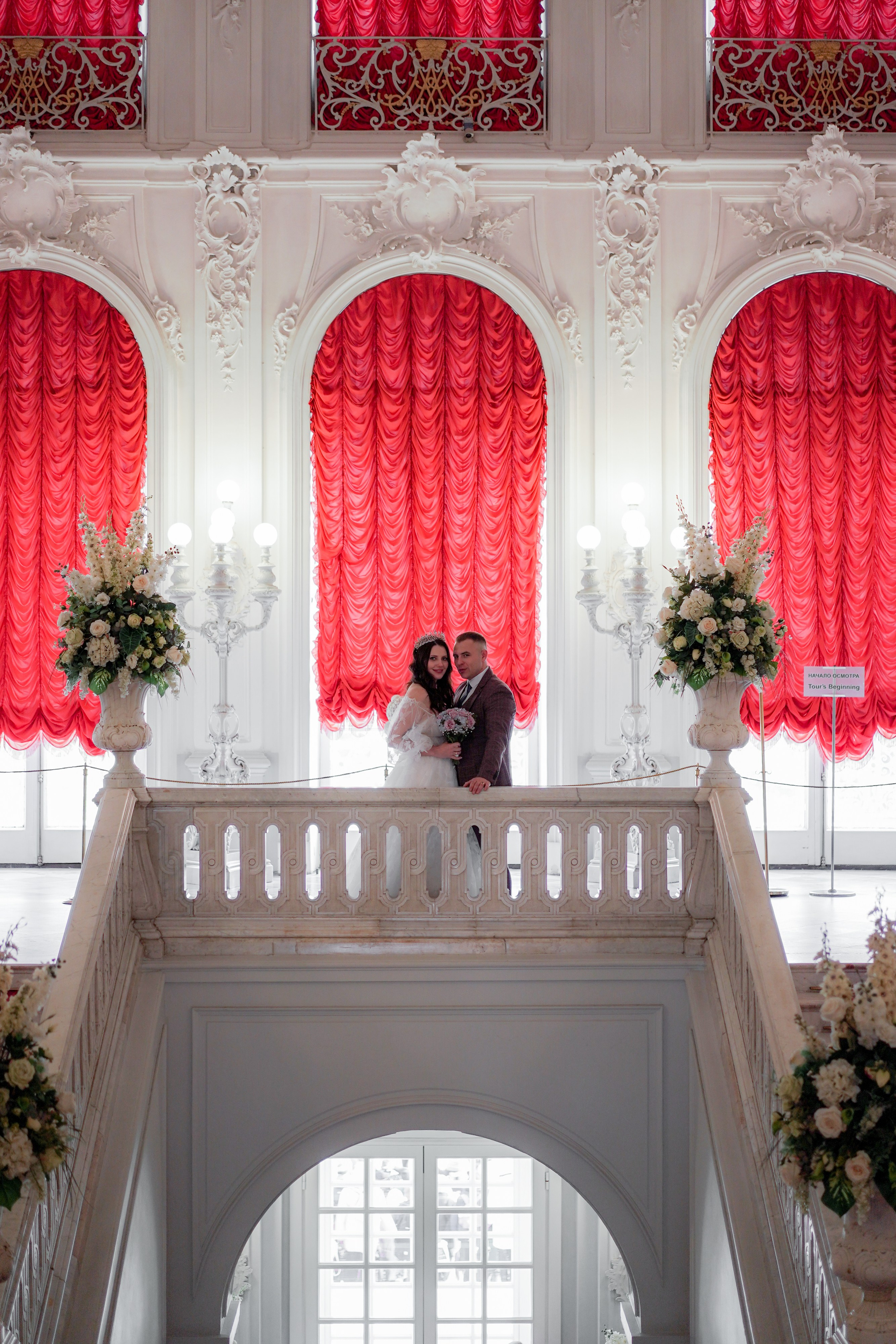 жених и невеста позируют на лестнице Екатерининского дворца в Пушкине