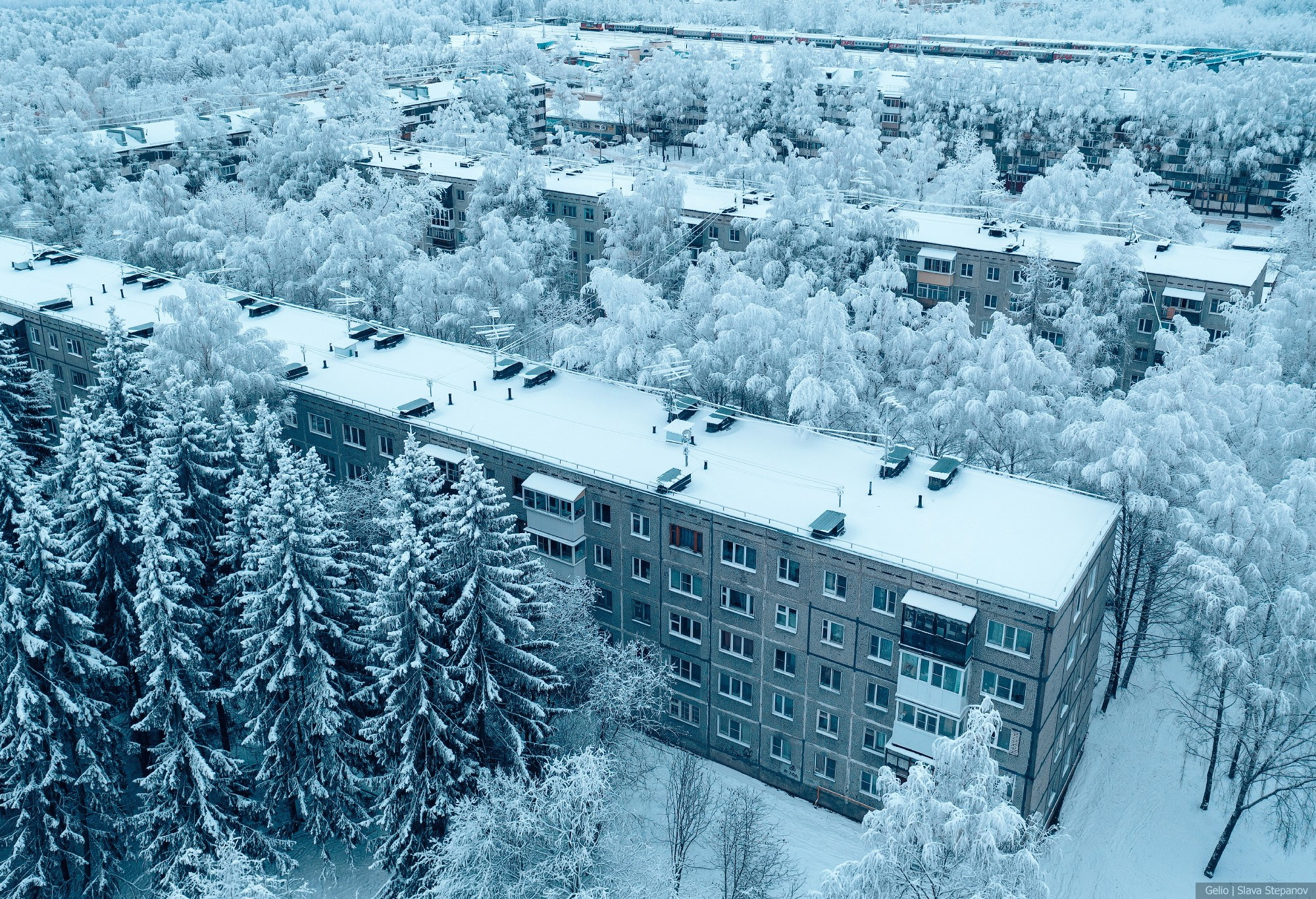 Snow-covered microdistrict of Syktyvkar from a bird's-eye view. Winter cityscape, five-story buildings, and heavily snow-covered trees. Photographer Slava Stepanov (Gelio).