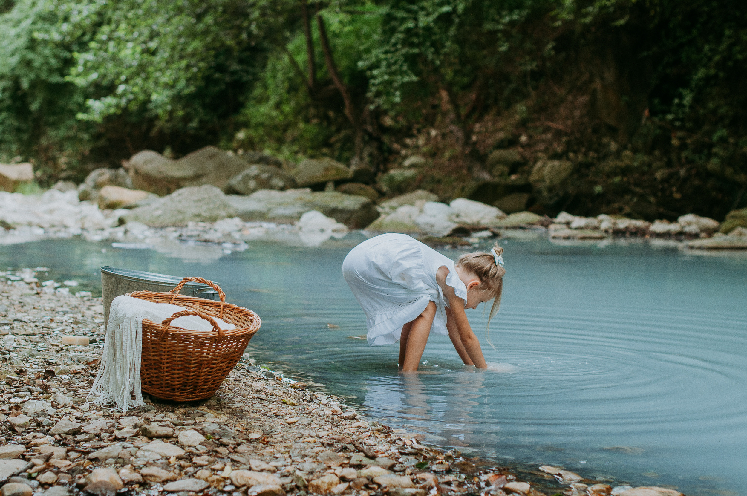 Девочка в белоснежном платье стирает вещи в реке Агура в Сочи
