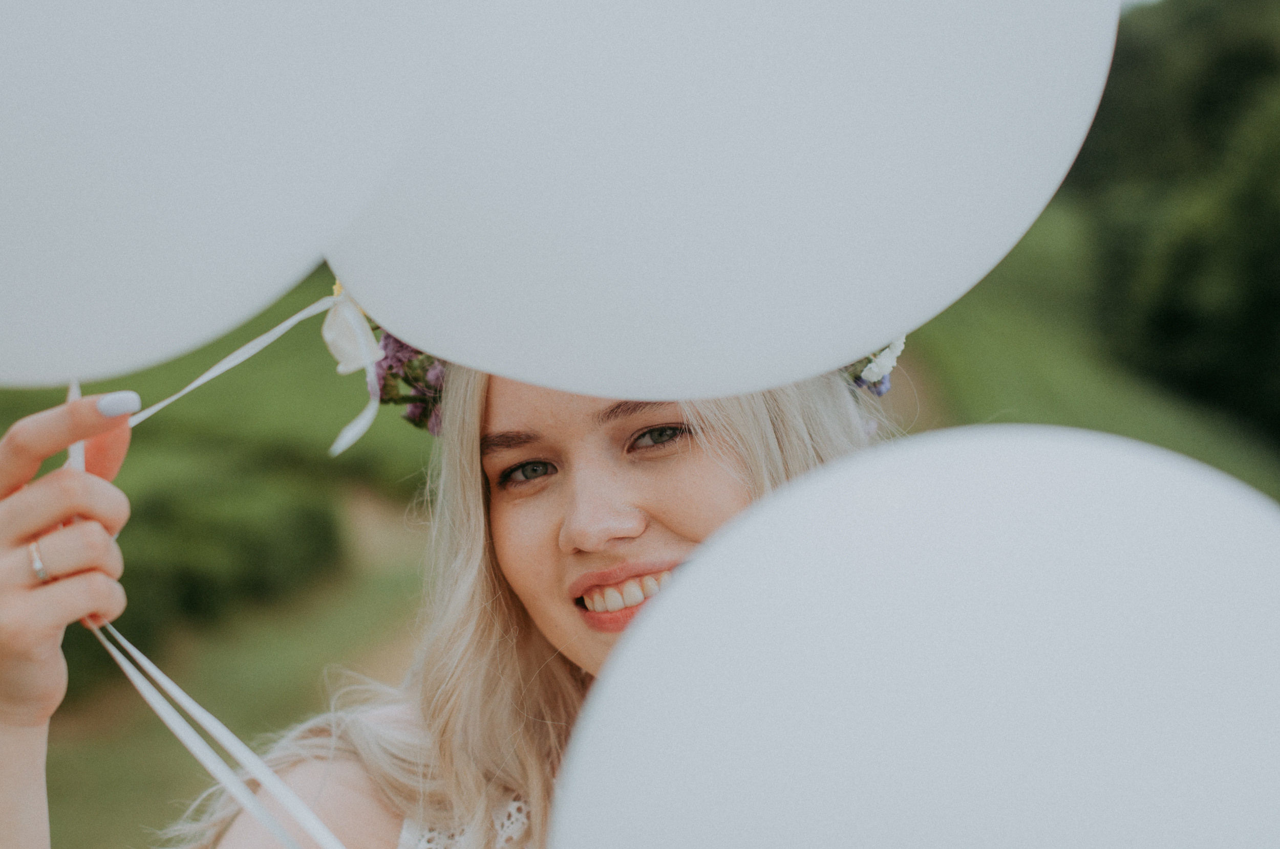 Невеста в цветочном венке с белыми воздушными шариками на девичнике на чайных плантациях в Сочи