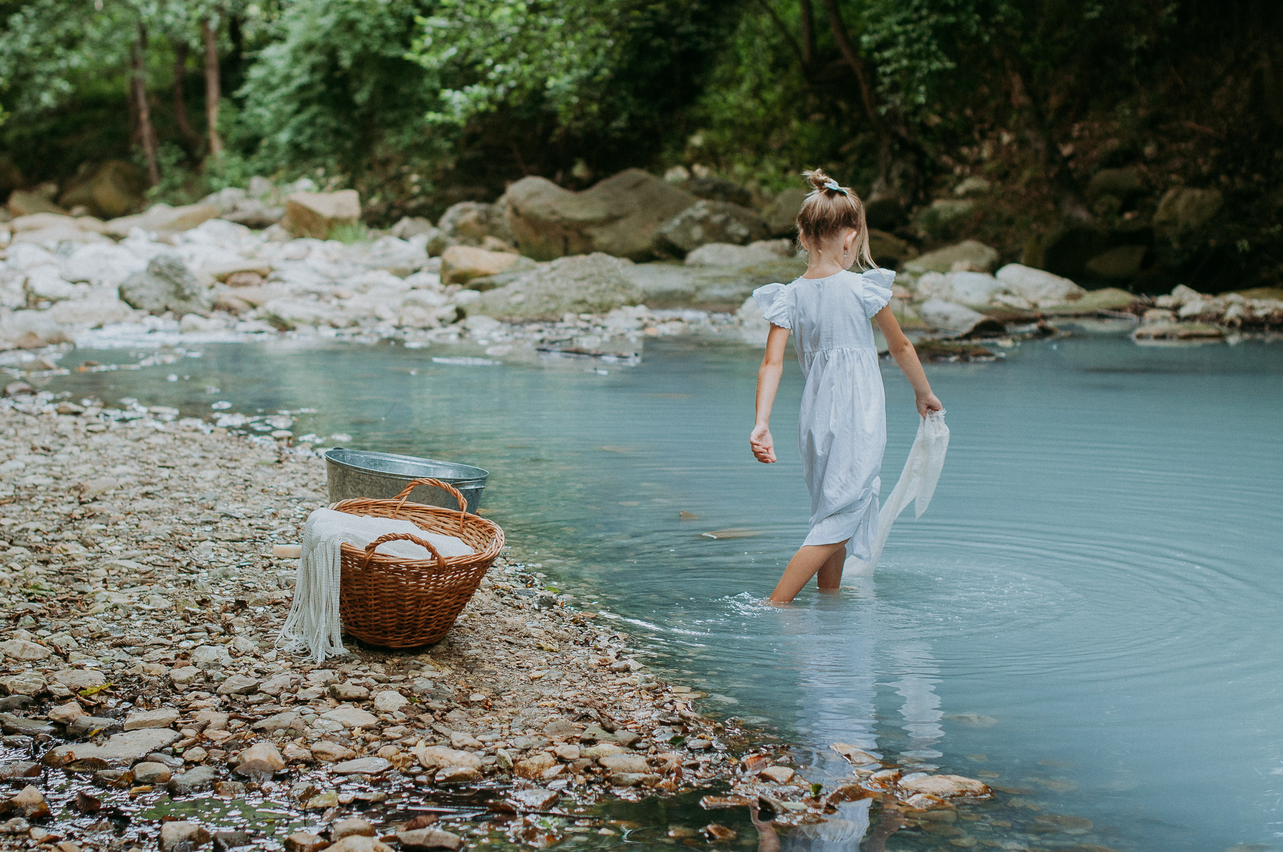 Девочка в белоснежном платье стирает вещи в реке Агура в Сочи