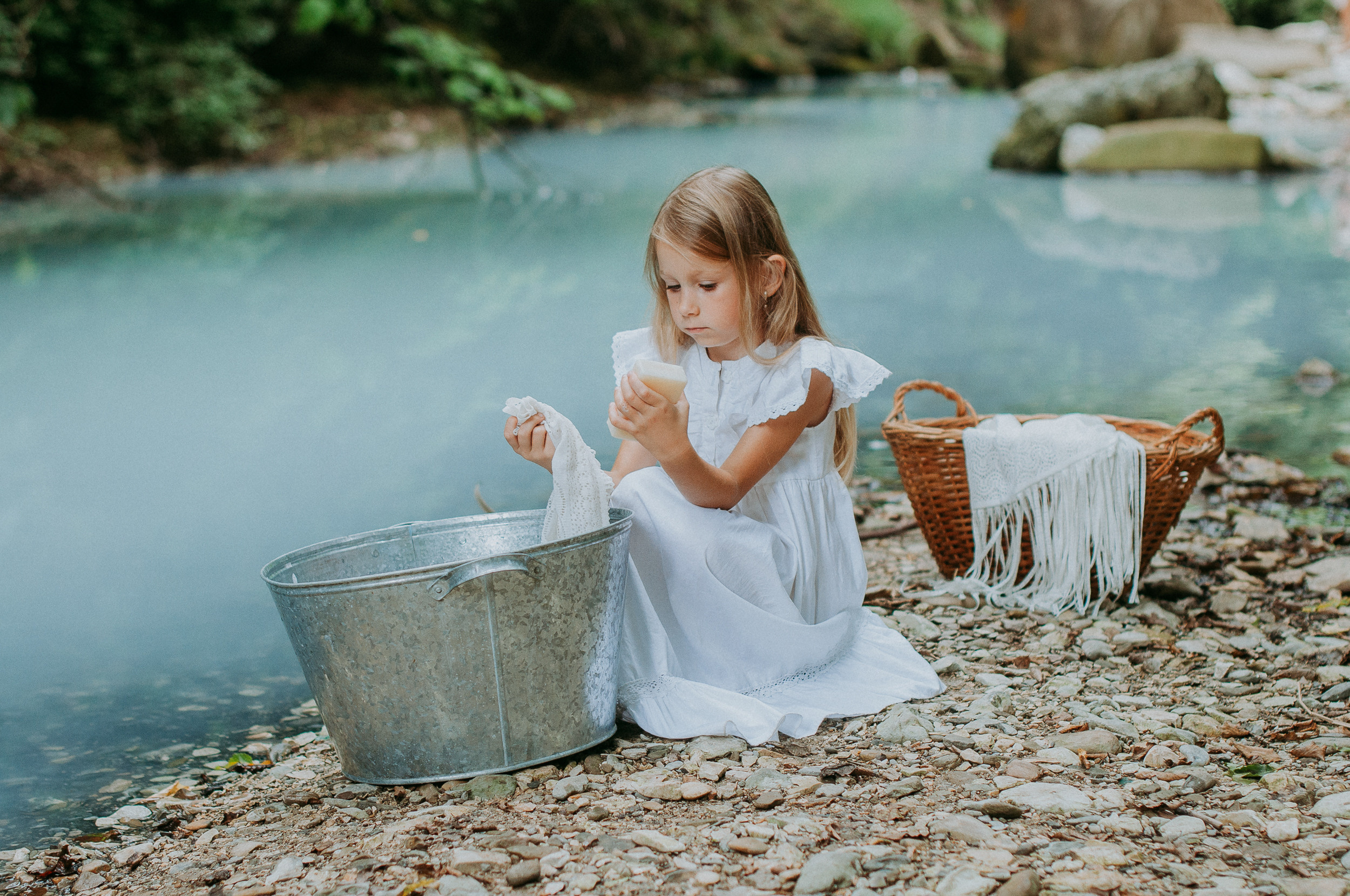 Девочка 6 лет стирает вещи в жестяном тазу на берегу реки Агура в Сочи