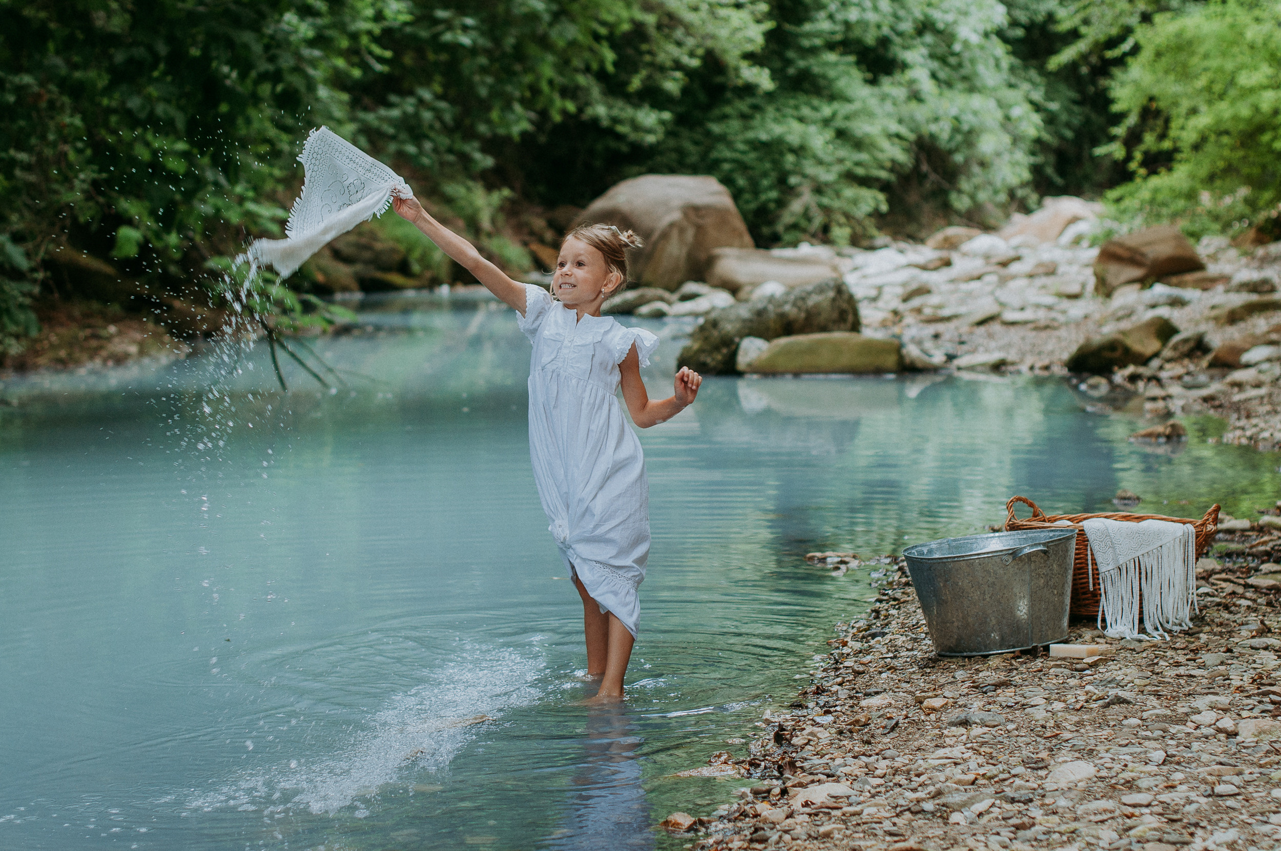 Девочка в белоснежном платье стирает вещи в реке Агура в Сочи