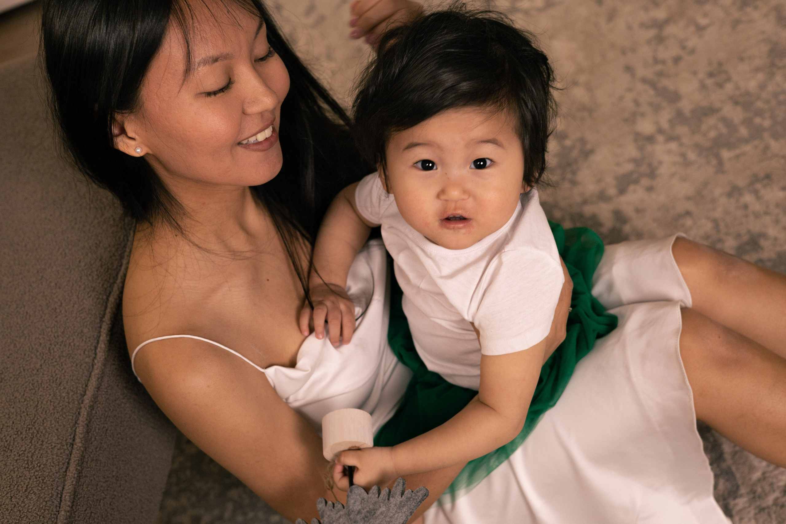 Маленькая дочка сидит у мамы на коленях смотрит вверх