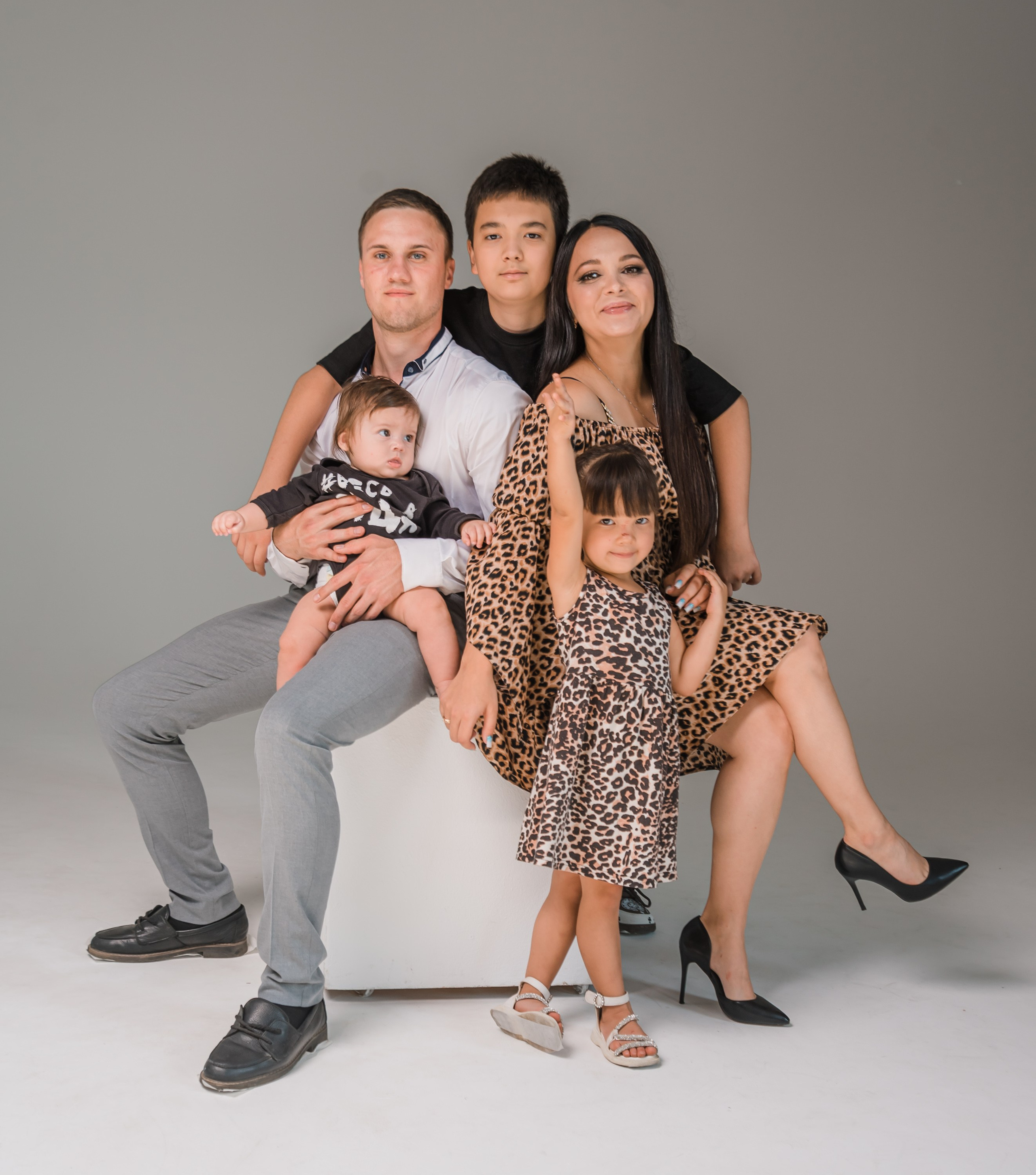 Семейное фото на сером фоне на кубе.
