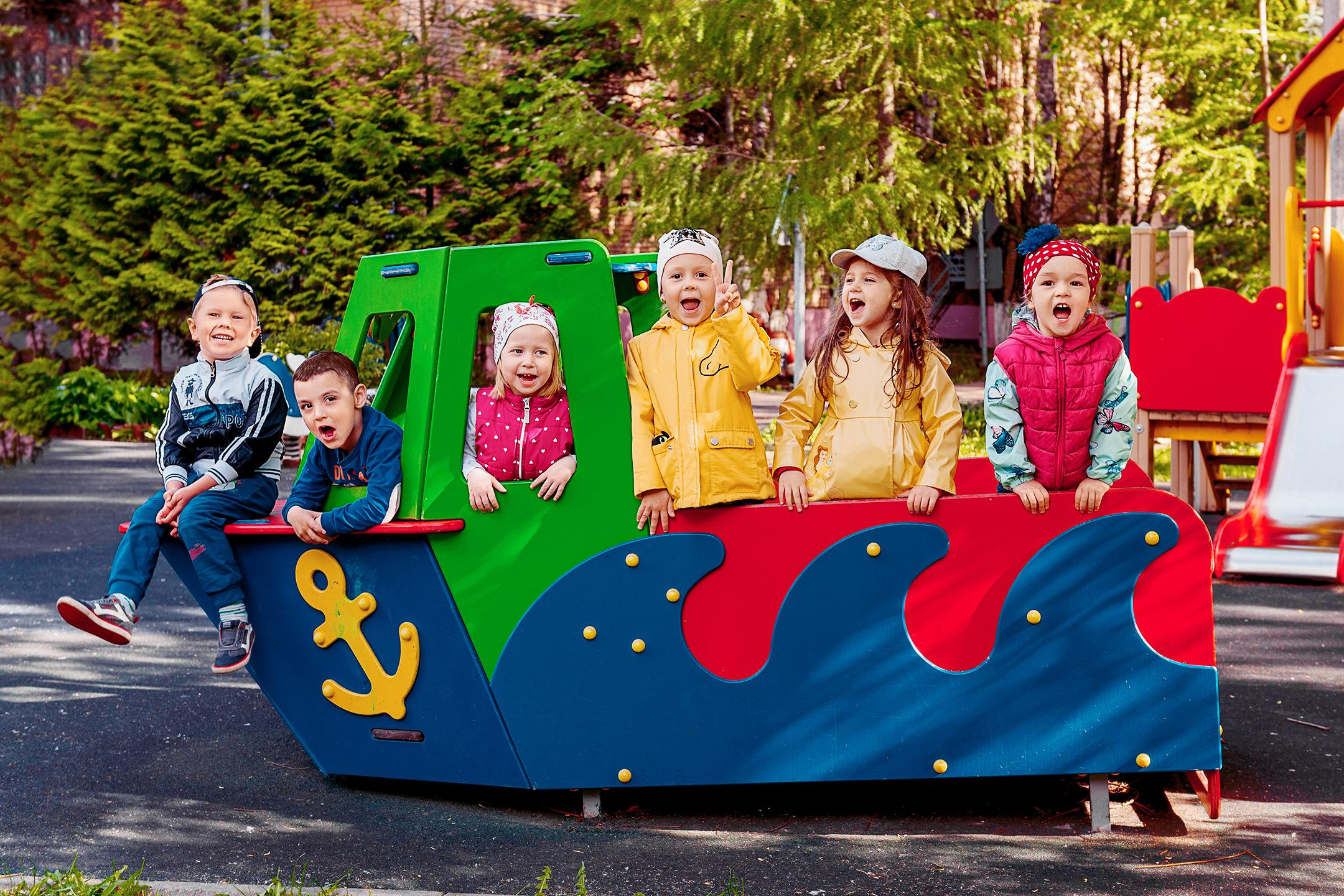 Шестеро детей забрались на игрушечный деревянный катер на территории детского сада.