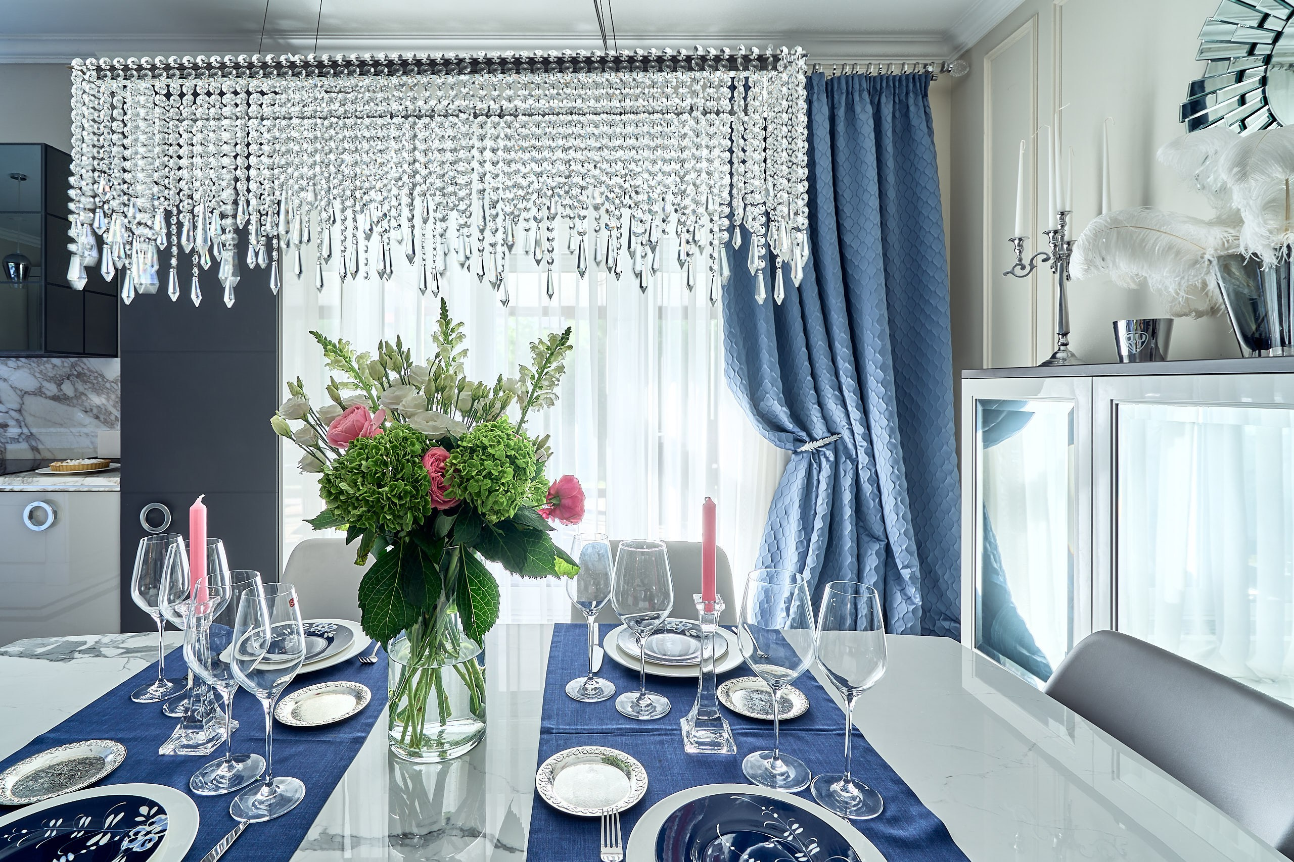 Интерьерная съемка в гостиной таунхауса с крупным планом букета и люстрой над обеденным столом