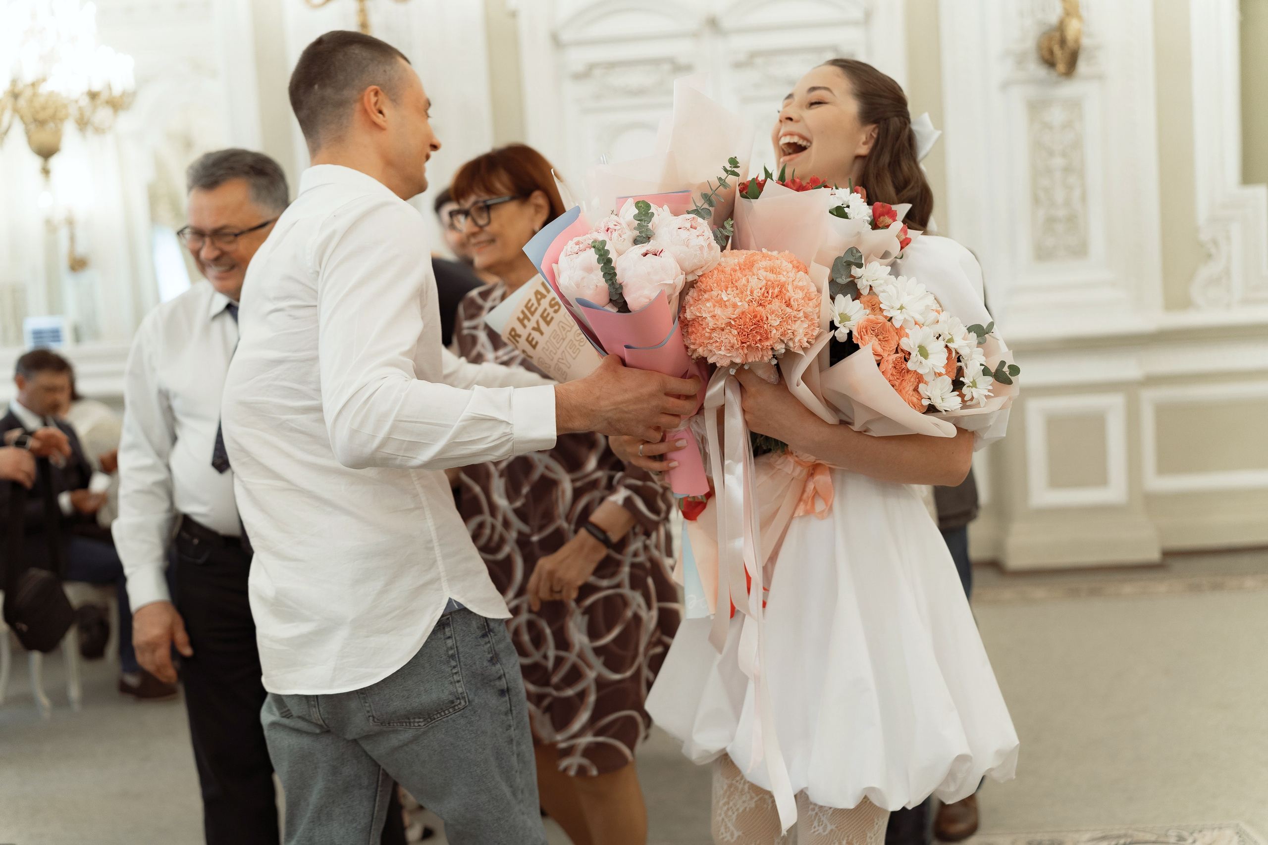 Молодожёны получают цветы и поздравления от гостей после церемонии