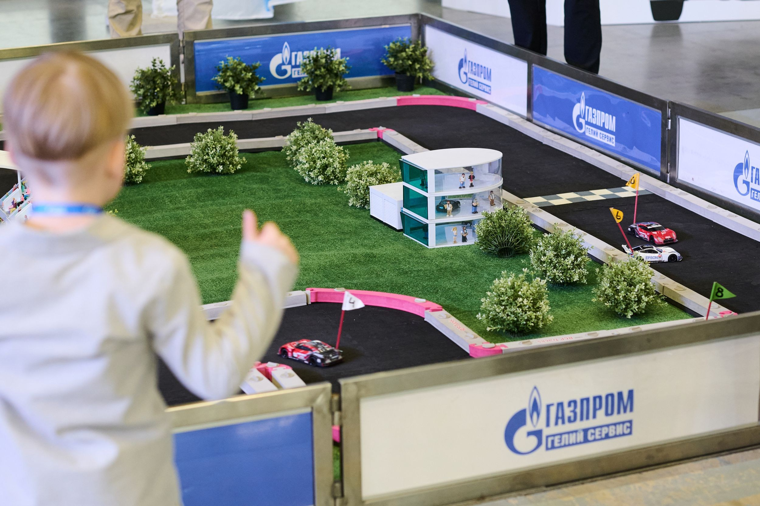 Игровая зона с мини-трассой и маленькой машиной на Петербургском международном газовом форуме 2025 в Экспофоруме