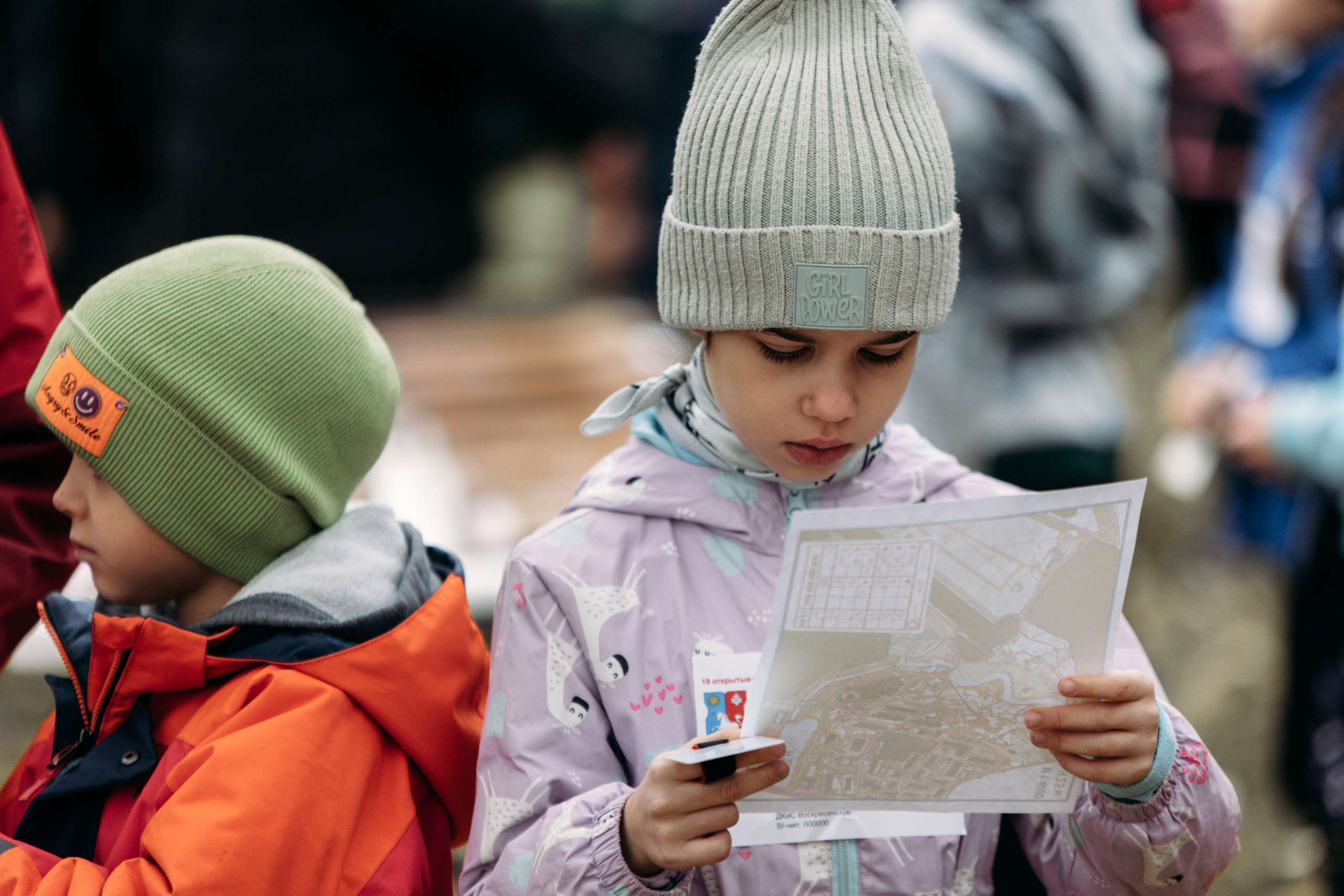 Девочка держит карту по спортивному ориентированию