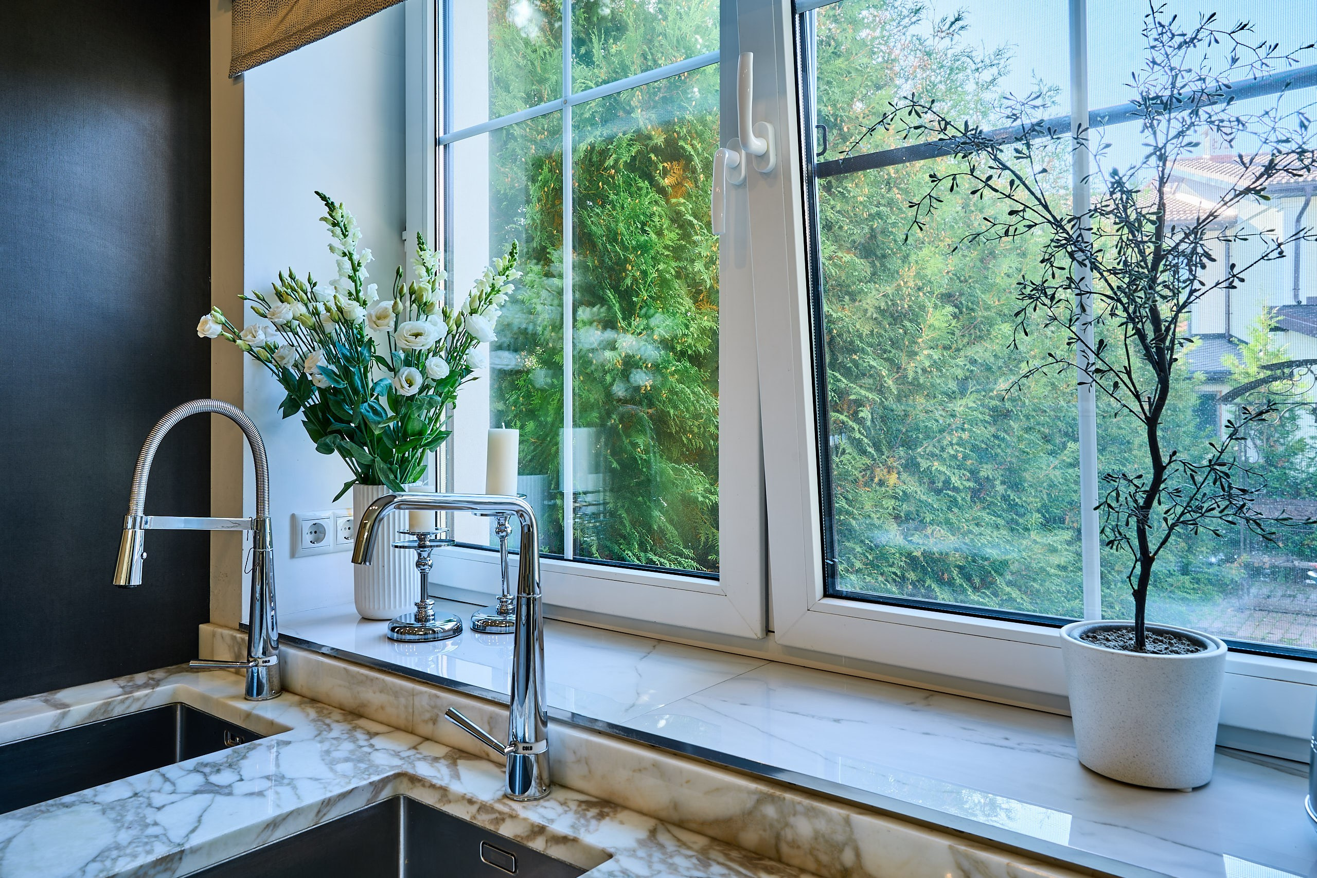 Интерьерная фотография с мойкой, кранами, букетом, декором и видом из окон на кухне таунхауса в Подмосковье