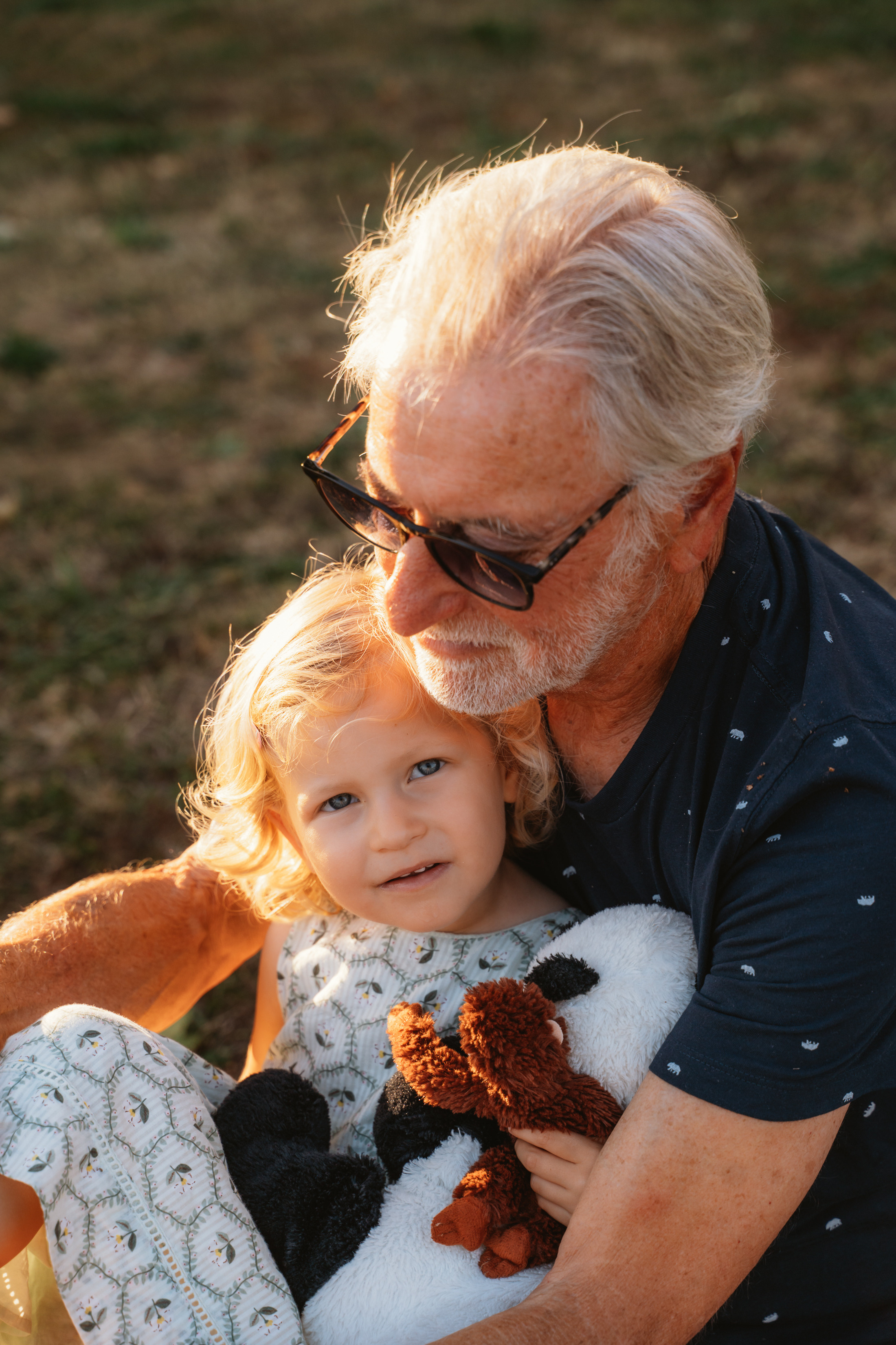 Smiling grandfather and granddaughter enjoying a sunny day in the Tuscan countryside.