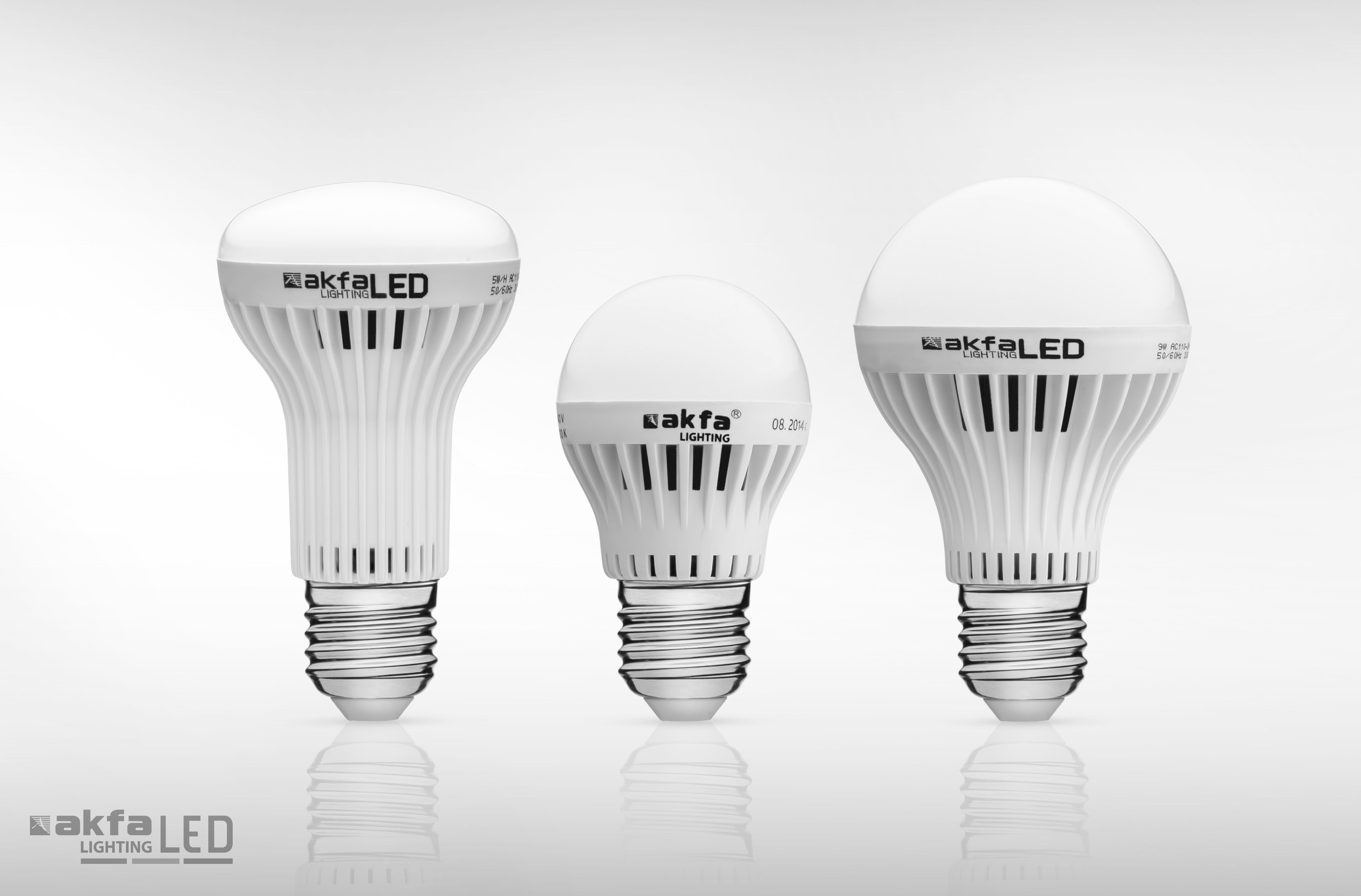 Линейка из трёх LED-ламп разной формы и мощности — студийная фотография ассортимента электротоваров на белом фоне