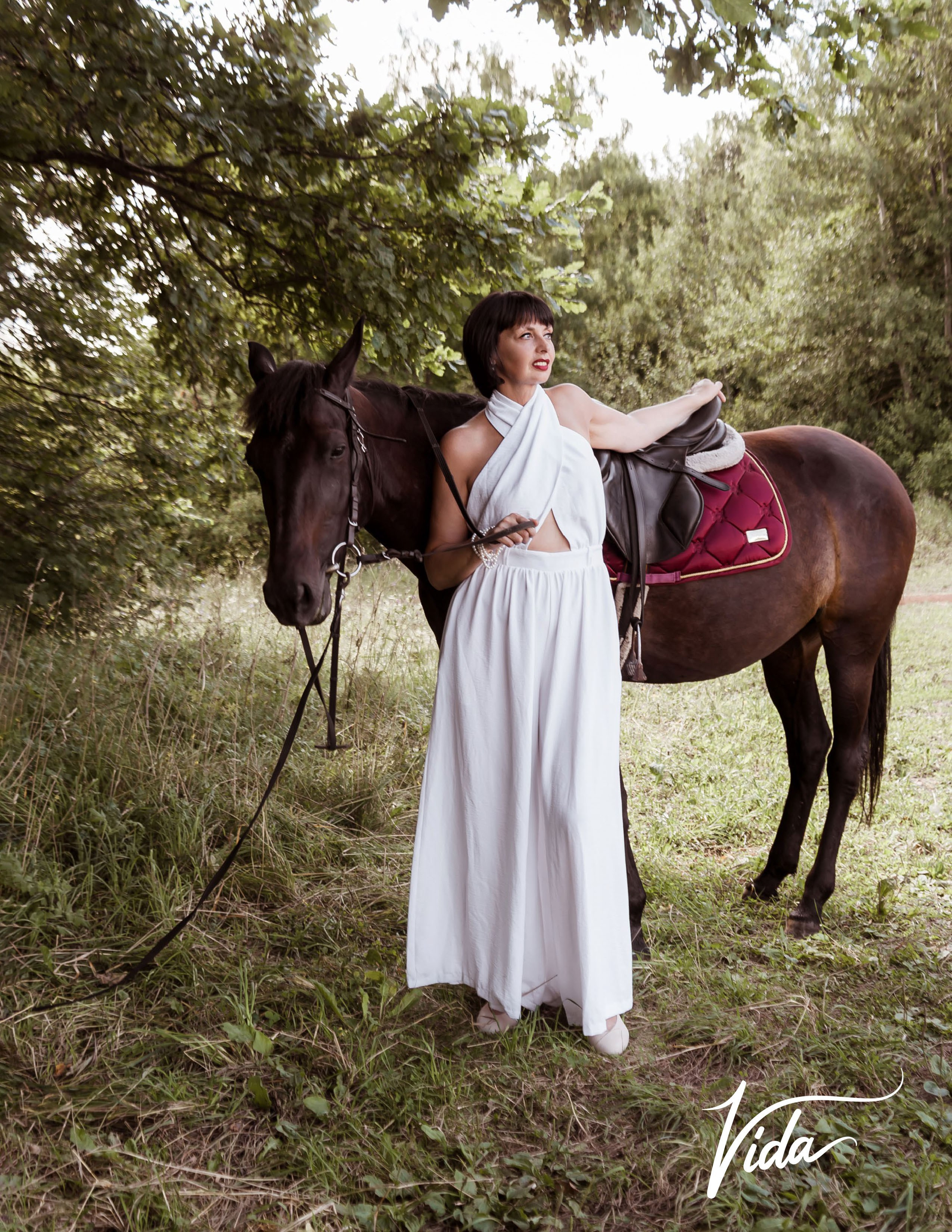 На фото отрывной лист журнала и девушка в белом комбинезоне с лошадью