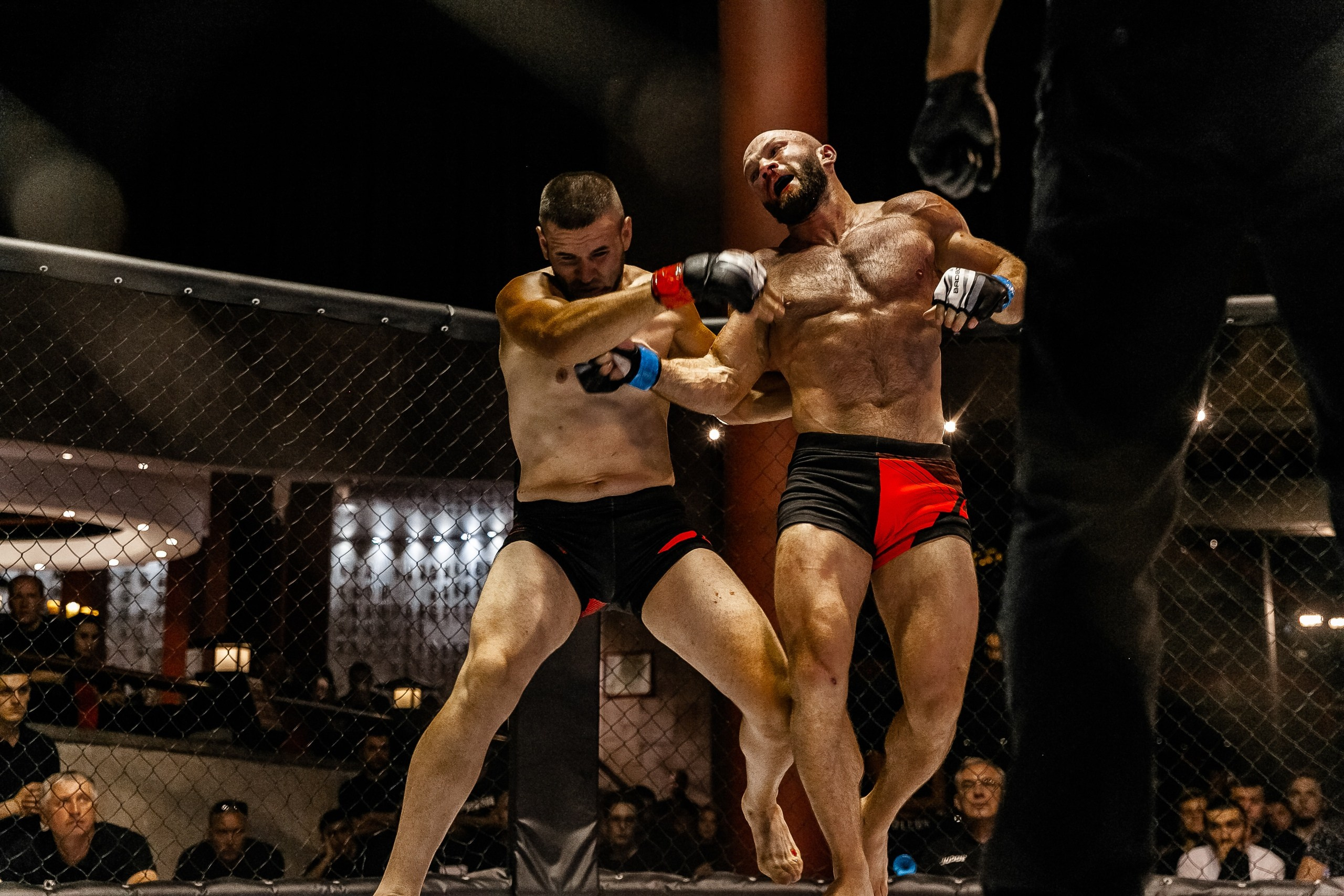 Боец делает удар в лицо в октагоне MMA репортажная фотография