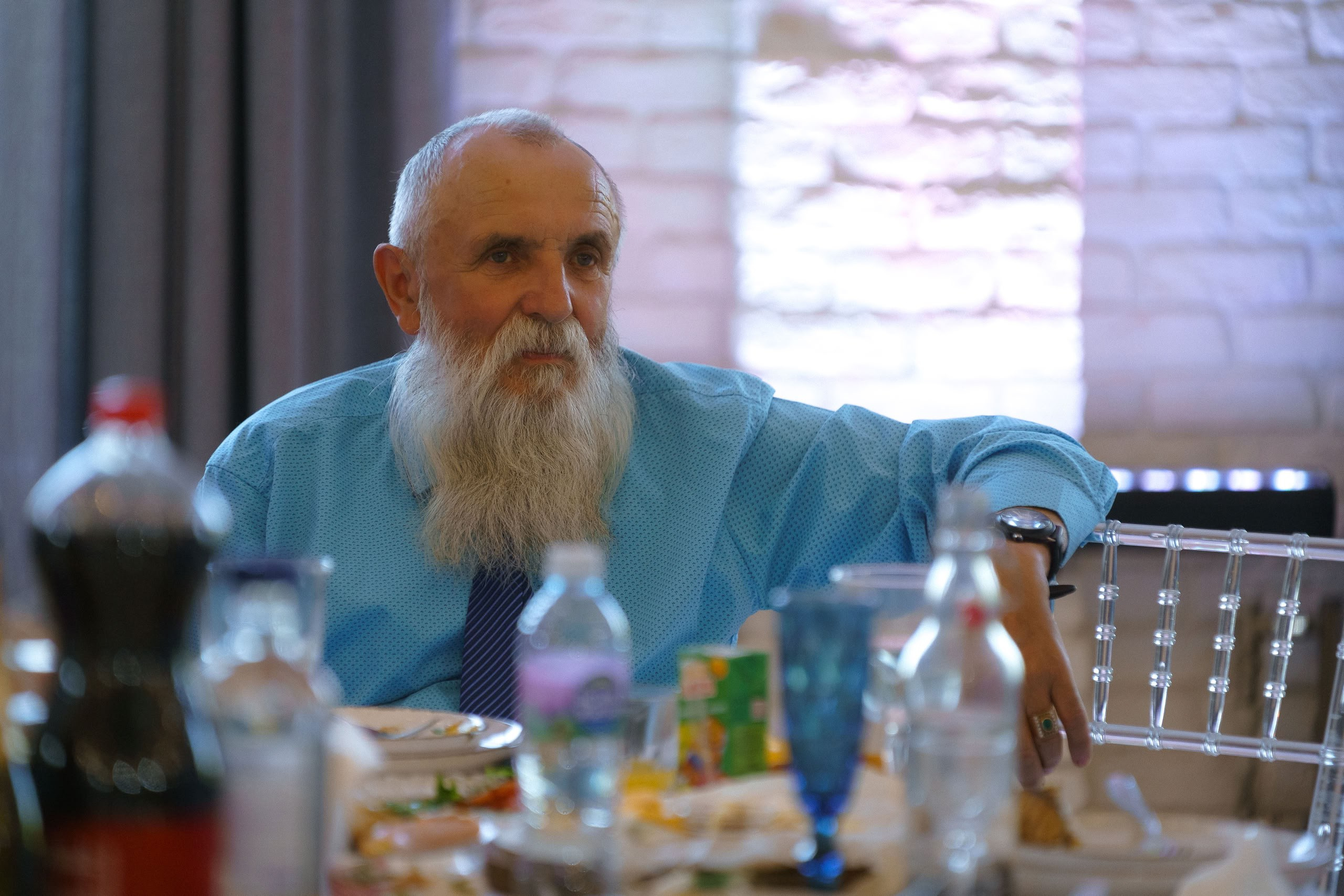 Пожилой гость за столом на свадебном банкете