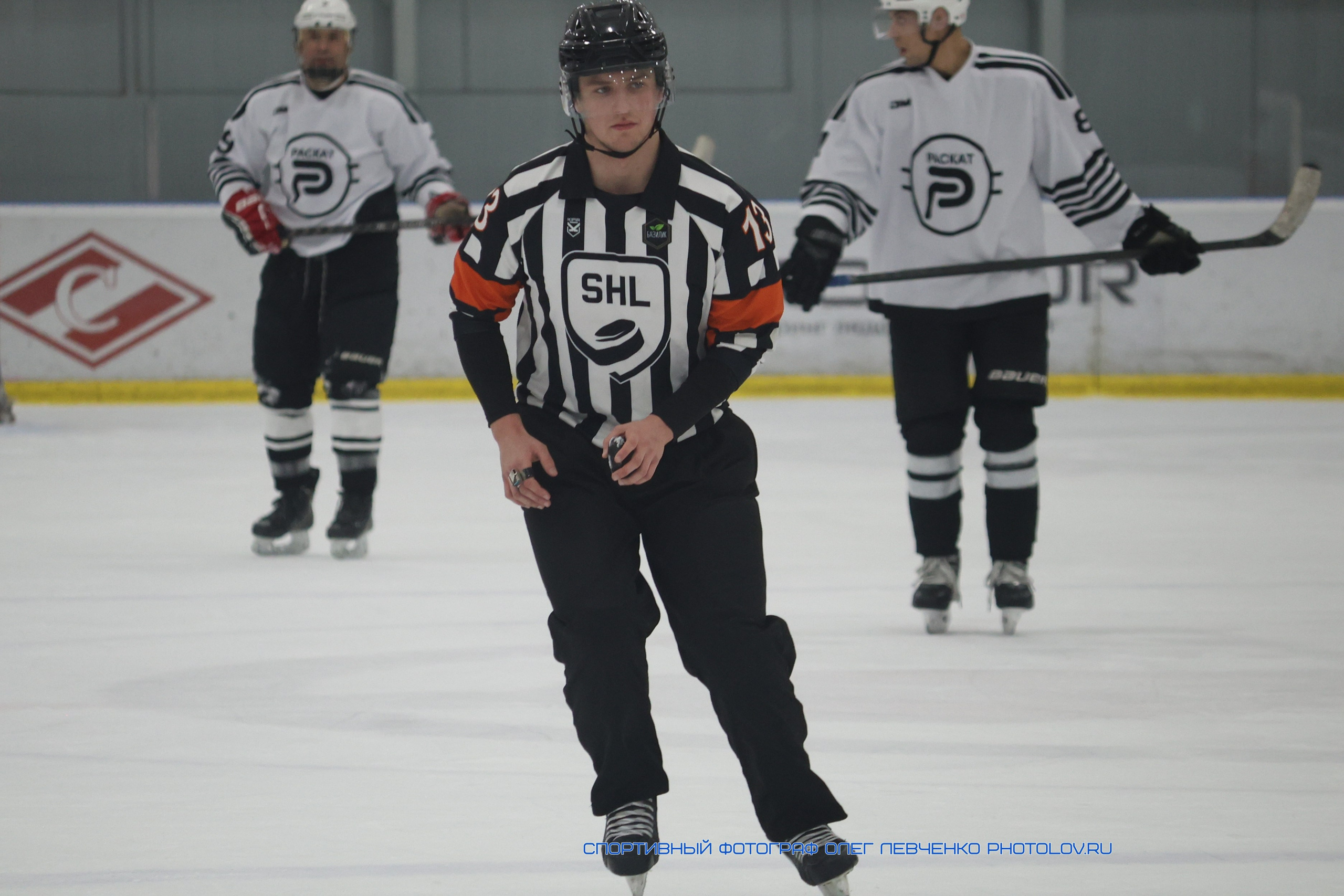 Судья ведет игроков в хоккей в зону сбрасывания