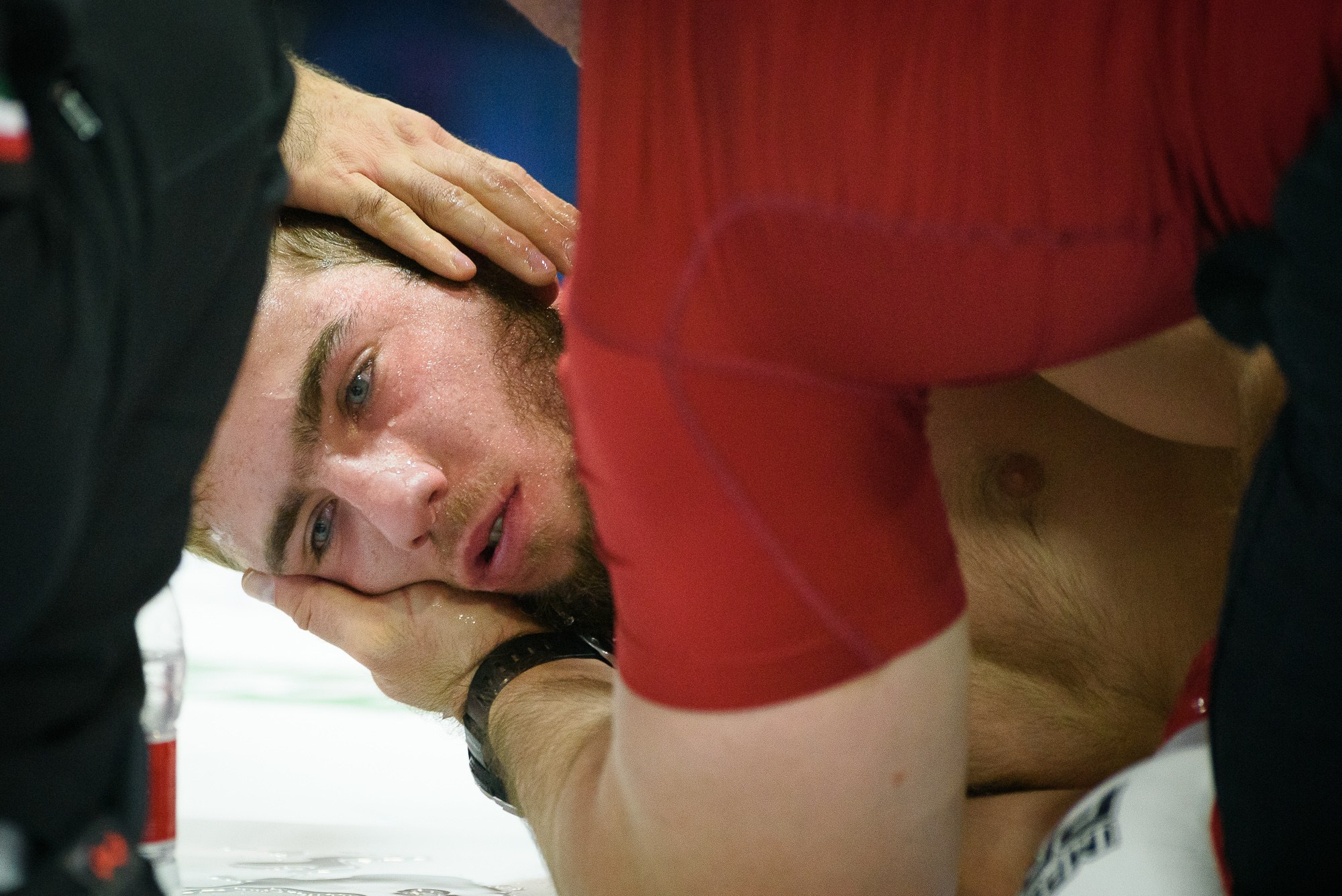 Помощники спортсмена, потерявшего сознание, поддерживают его голову