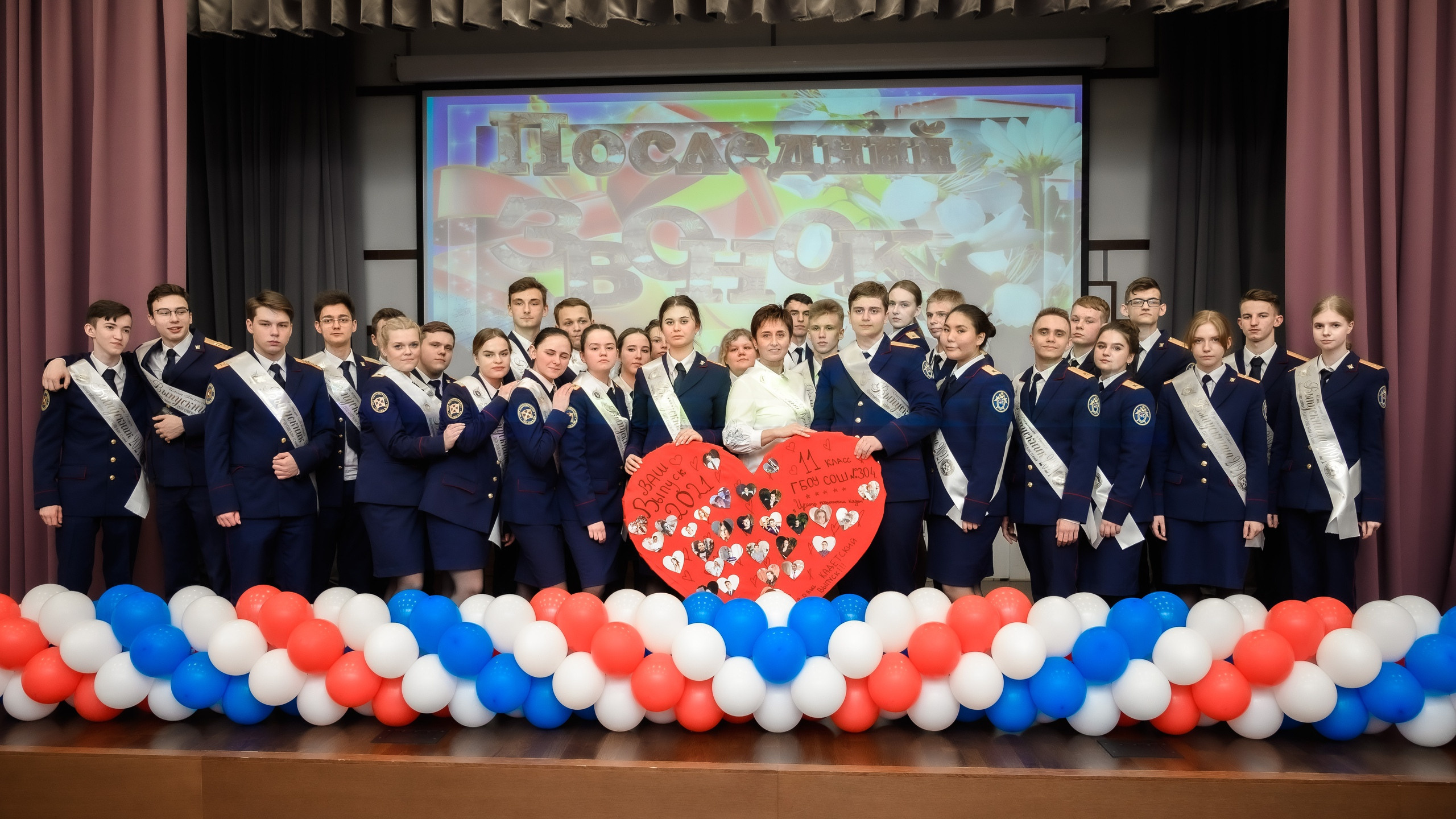 выпускники на сцене с учителем на последнем звонке