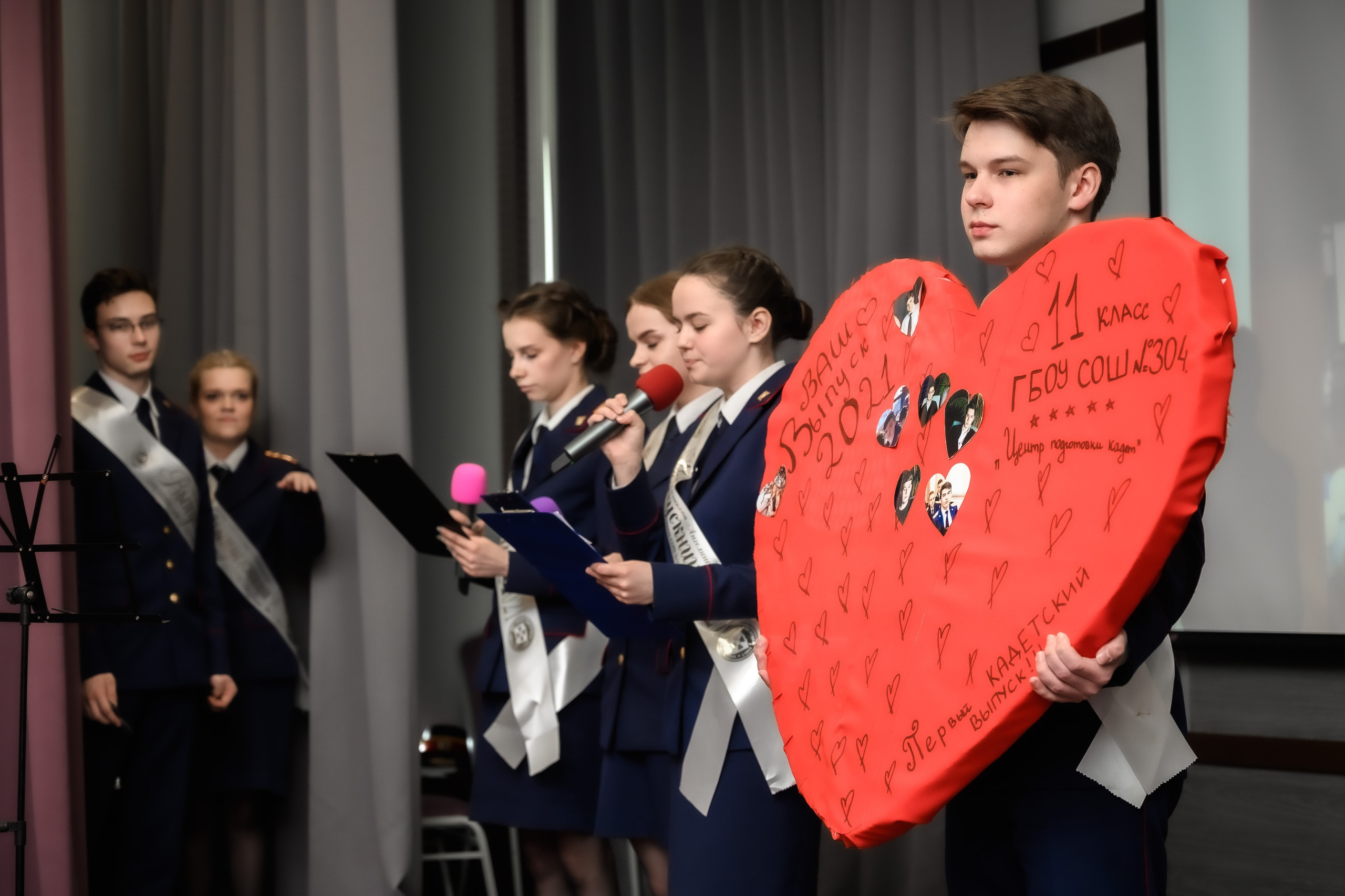 Последний звонок в школе, выпускники на сцене.