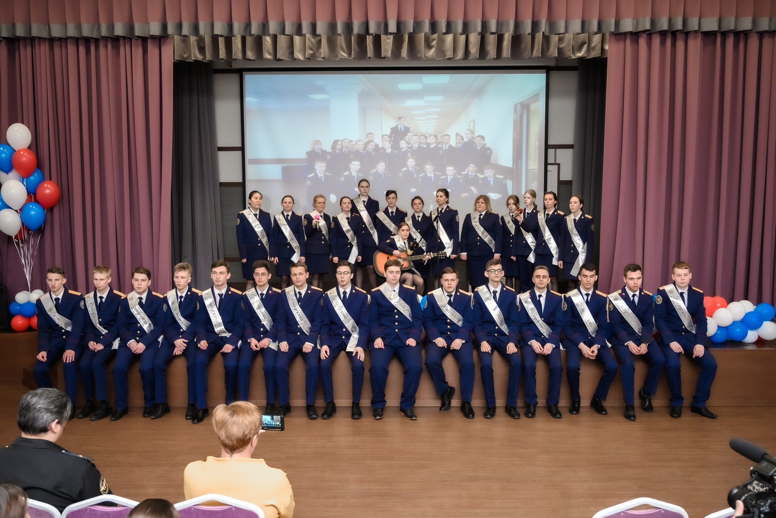 Последний звонок в актовом зале, выступление выпускников на сцене